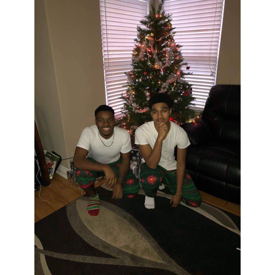 Just two brothers in front of a Christmas tree.