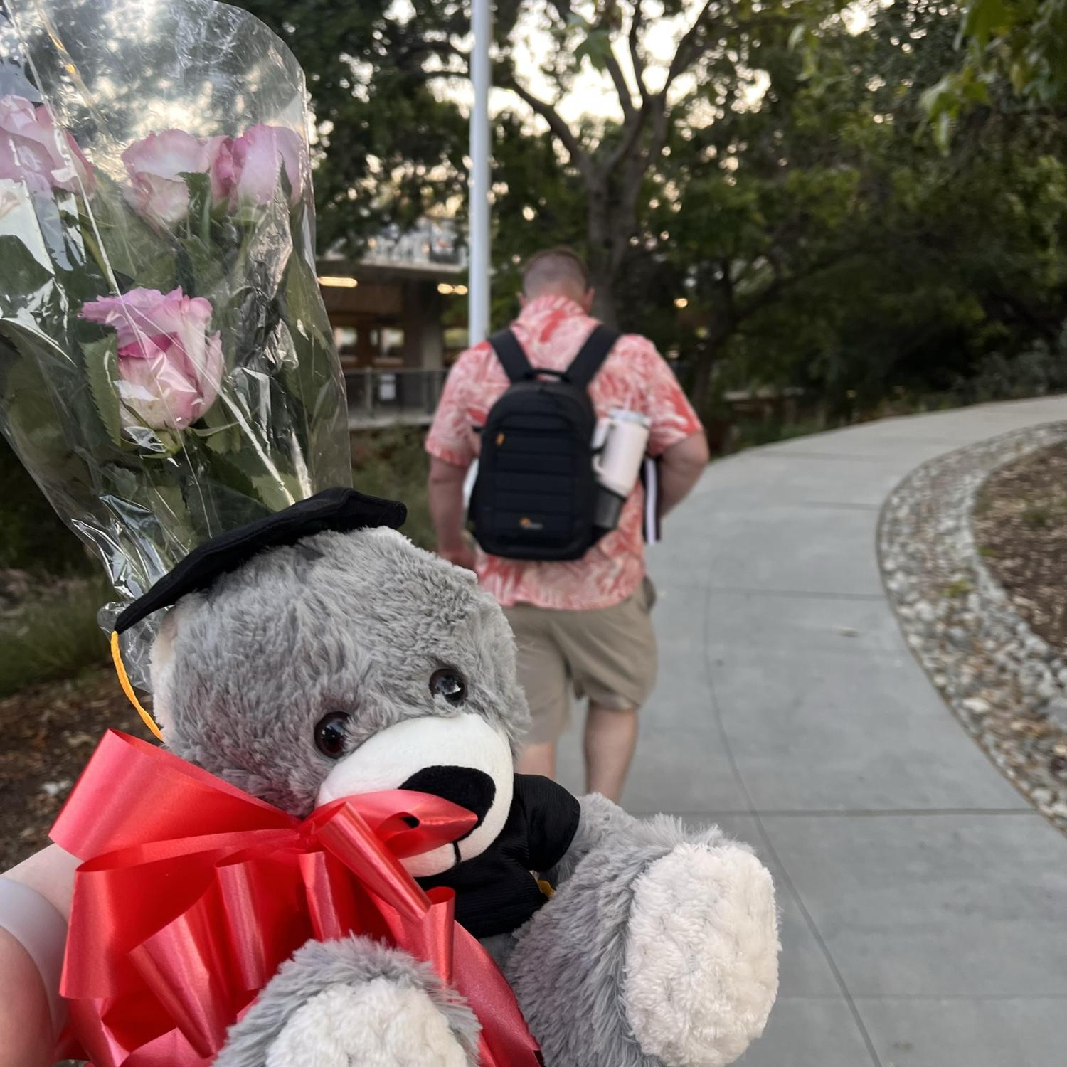 Quincy got me a teddy bear and roses for graduation. He's carrying his camera bag!