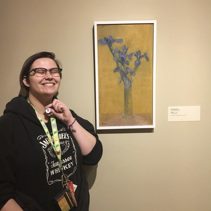 Alex posing next to a painting of an orchid with an orchid necklace Spencer gave her