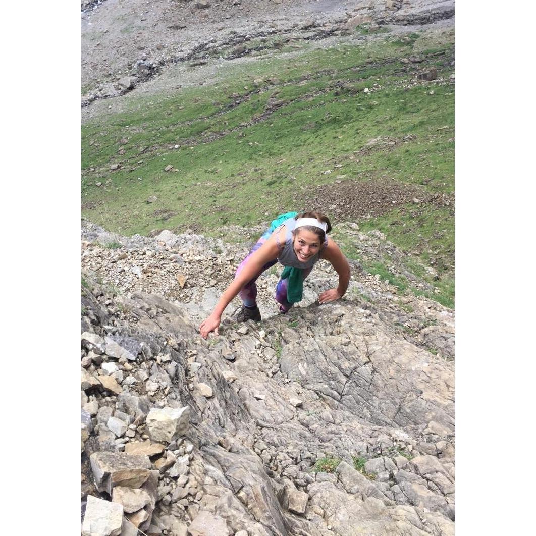 Jacqueline scrambles up a rock in the Cirque de Gavarnie, France.