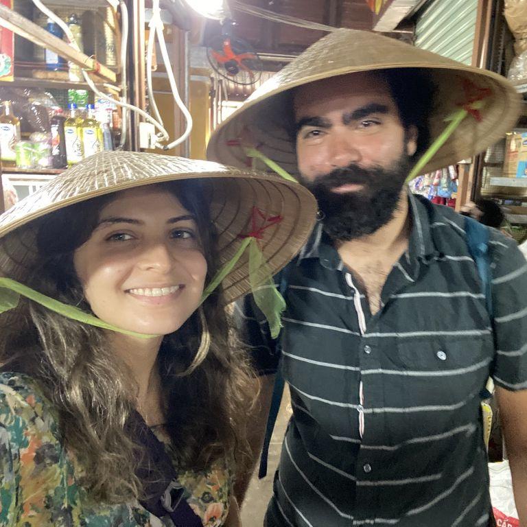 Negin convinced Kerem to join her on a food tour in Vietnam. It started in a bazaar to buy their groceries, where they wore these awesome hats. Kerem was less excited for the hat.