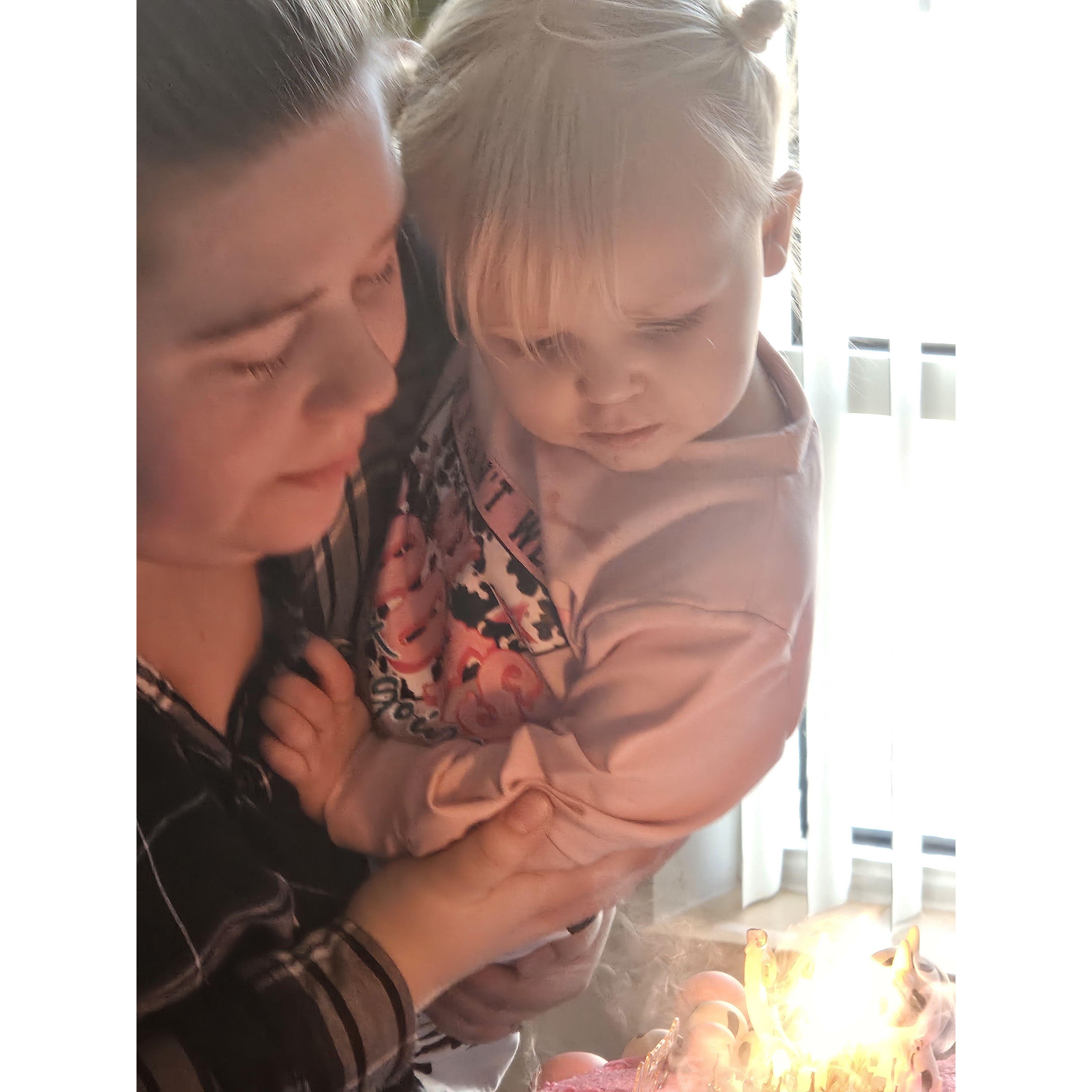 blowing the candles for her 2nd birthday