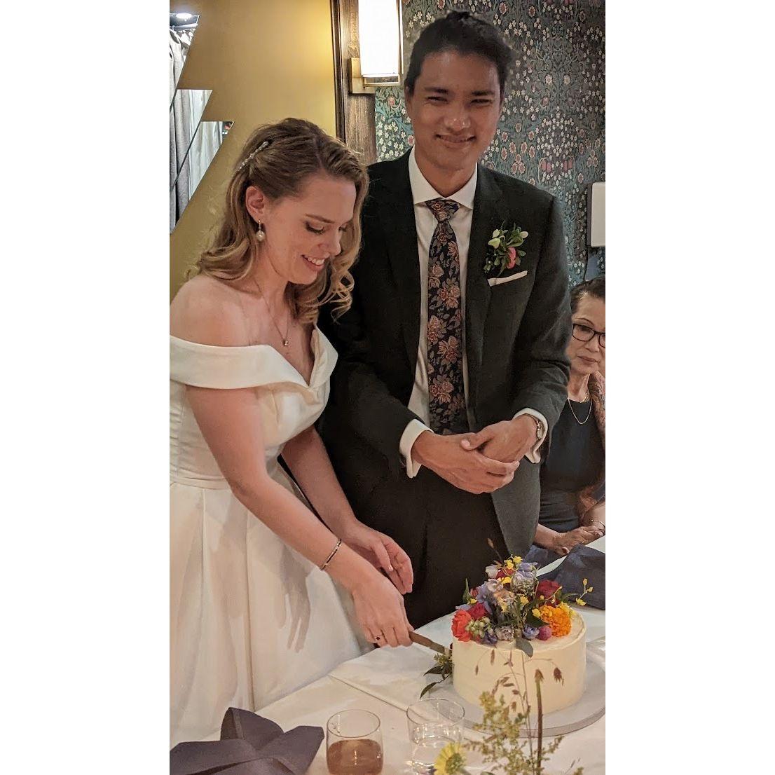 Caitlin & Nay cutting our wedding cake with our families