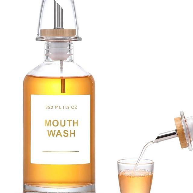 BONLONG 11.8OZ Glass Mouthwash Dispenser for Bathroom with Stainless Steel & Bamboo Nozzle, Mouthwash Cup Reusable, Bamboo Tray, and Elegant Gold Sticker.（Clear