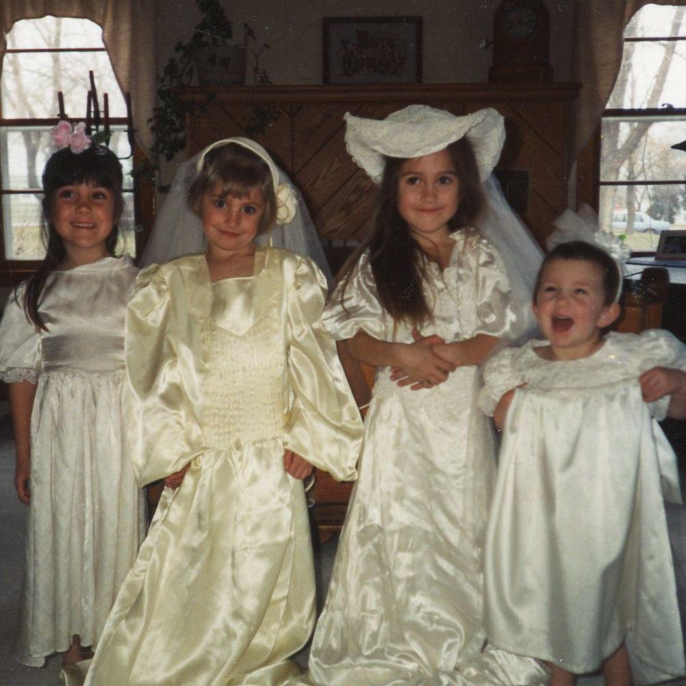 Nora's first wedding dress (far right). Along with her sister Tessa (second from the right) and cousins.