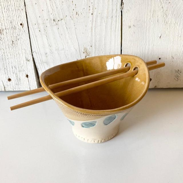 Ceramic noodle bowl with chopsticks, handmade ramen or rice bowl in golden brown