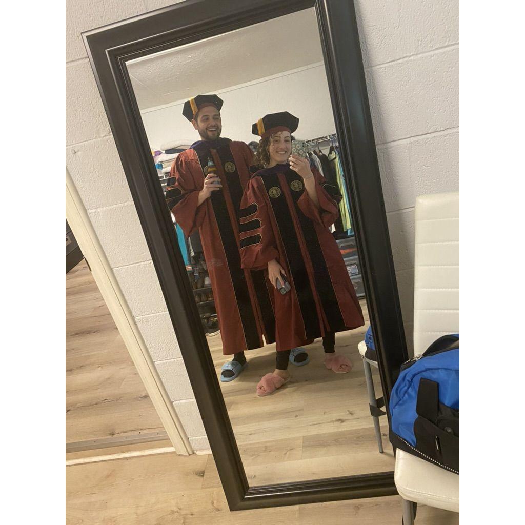 Trying on our caps and gowns at home months before graduation.