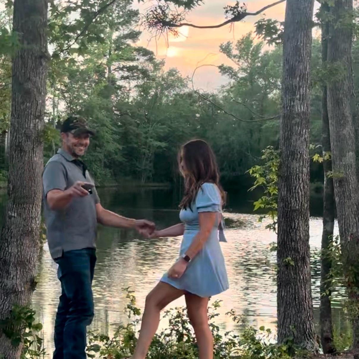 Pointing to the hidden camera capturing the proposal 🤭