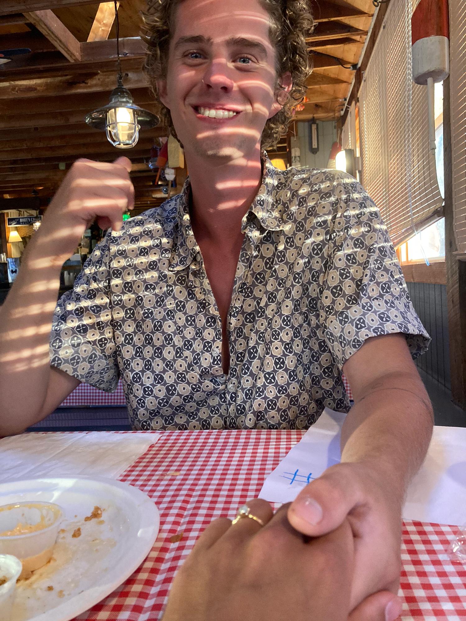 We got engaged in Wellfleet, Cape Cod. We were deep into a fried onion appetizer when this picture was taken.