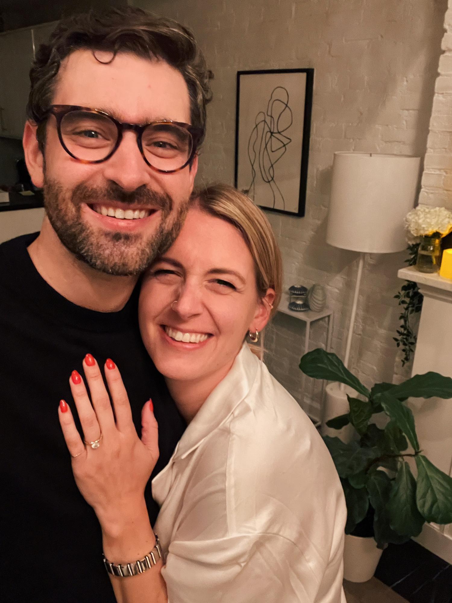 April 2022: the night we got engaged, in our apartment surrounded by candles and flowers, with a projector shining on our walls years of videos of the two of us.
