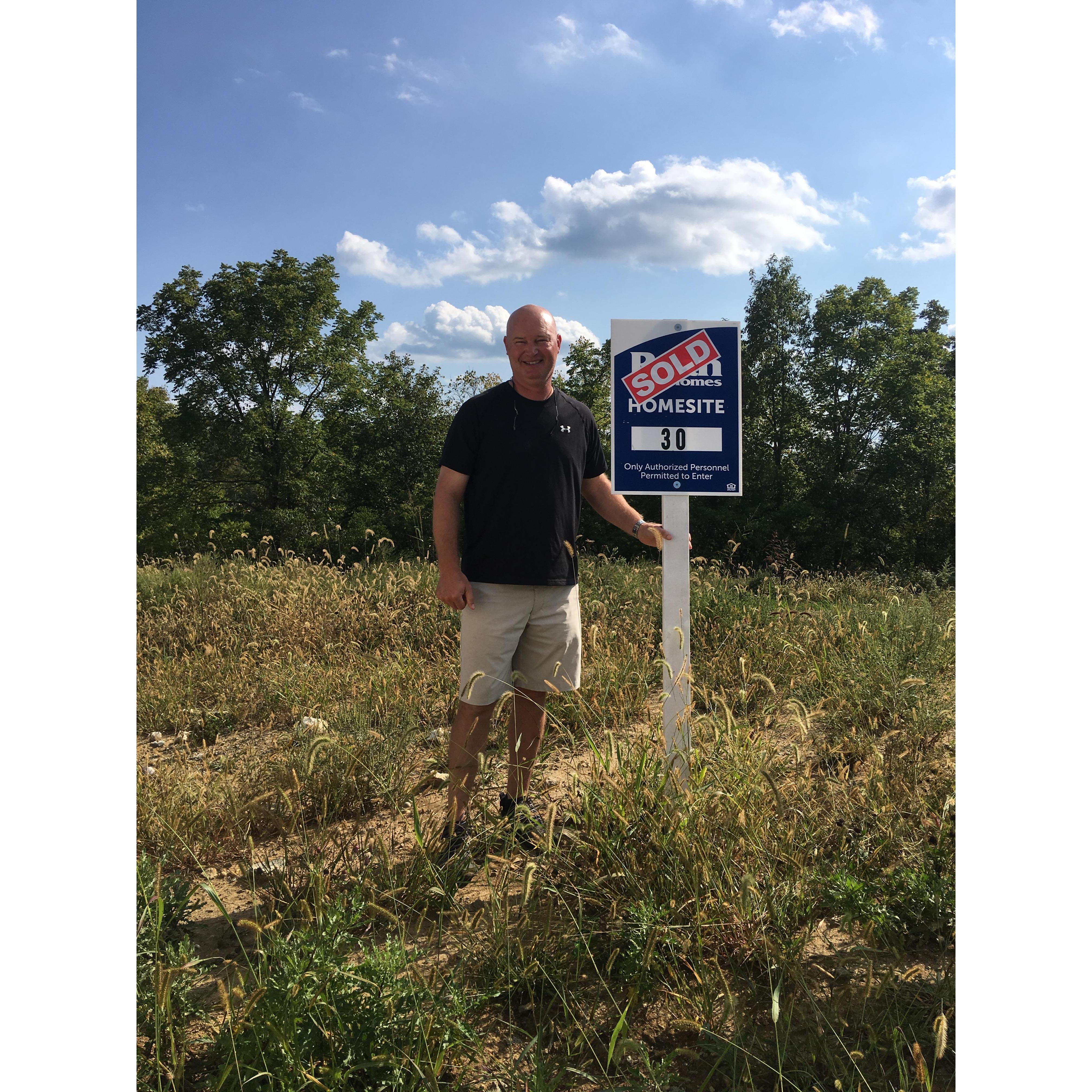 Someone just bought a lot to build a new home! He looks mighty happy!