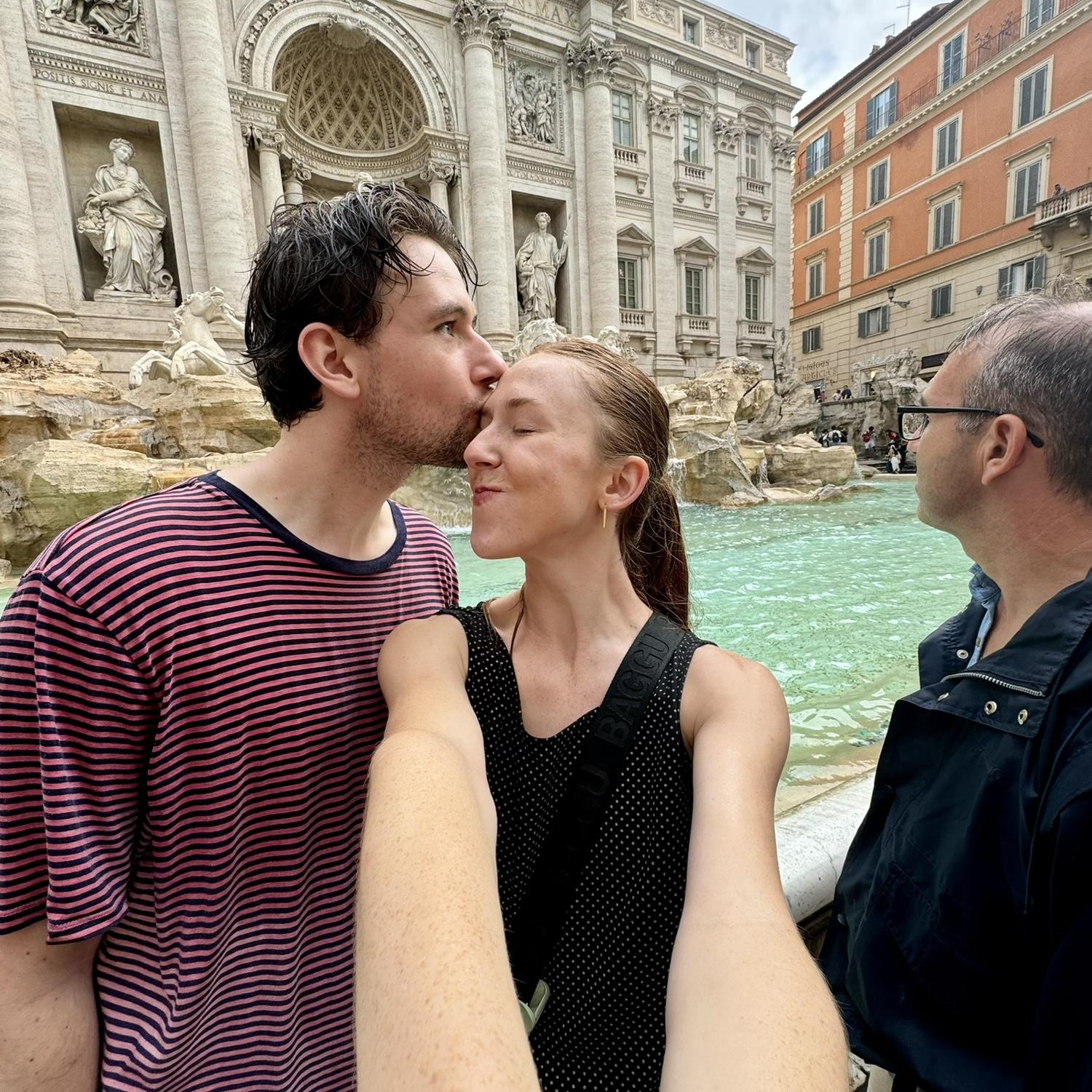 A smooch in Rome, Italy! Luke would like to clarify this was after a sudden rain shower and THAT is why he is drenched. There are no rules against being drenched.