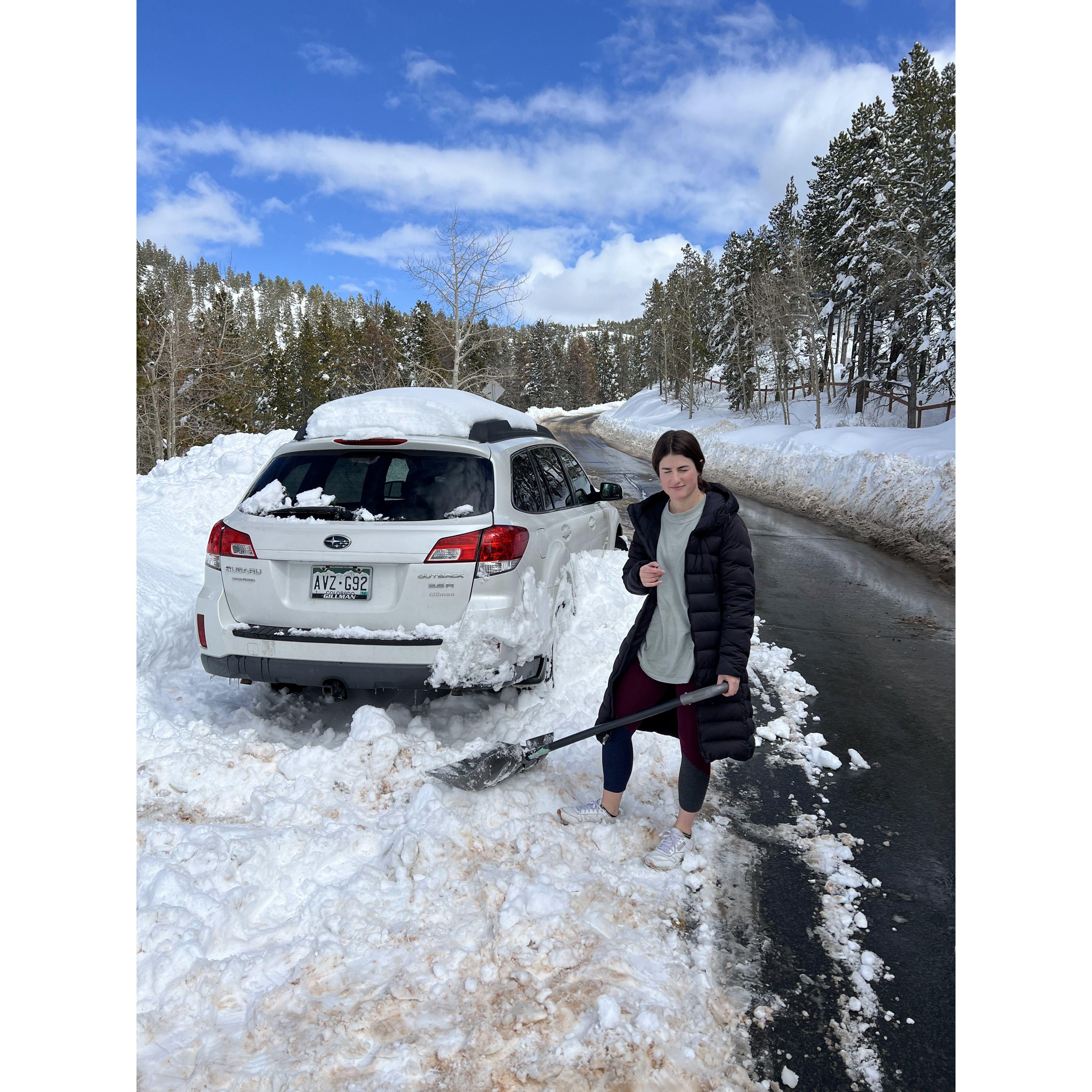 Lizzy helping dig Joe's car out of the snow after it died in the mountains