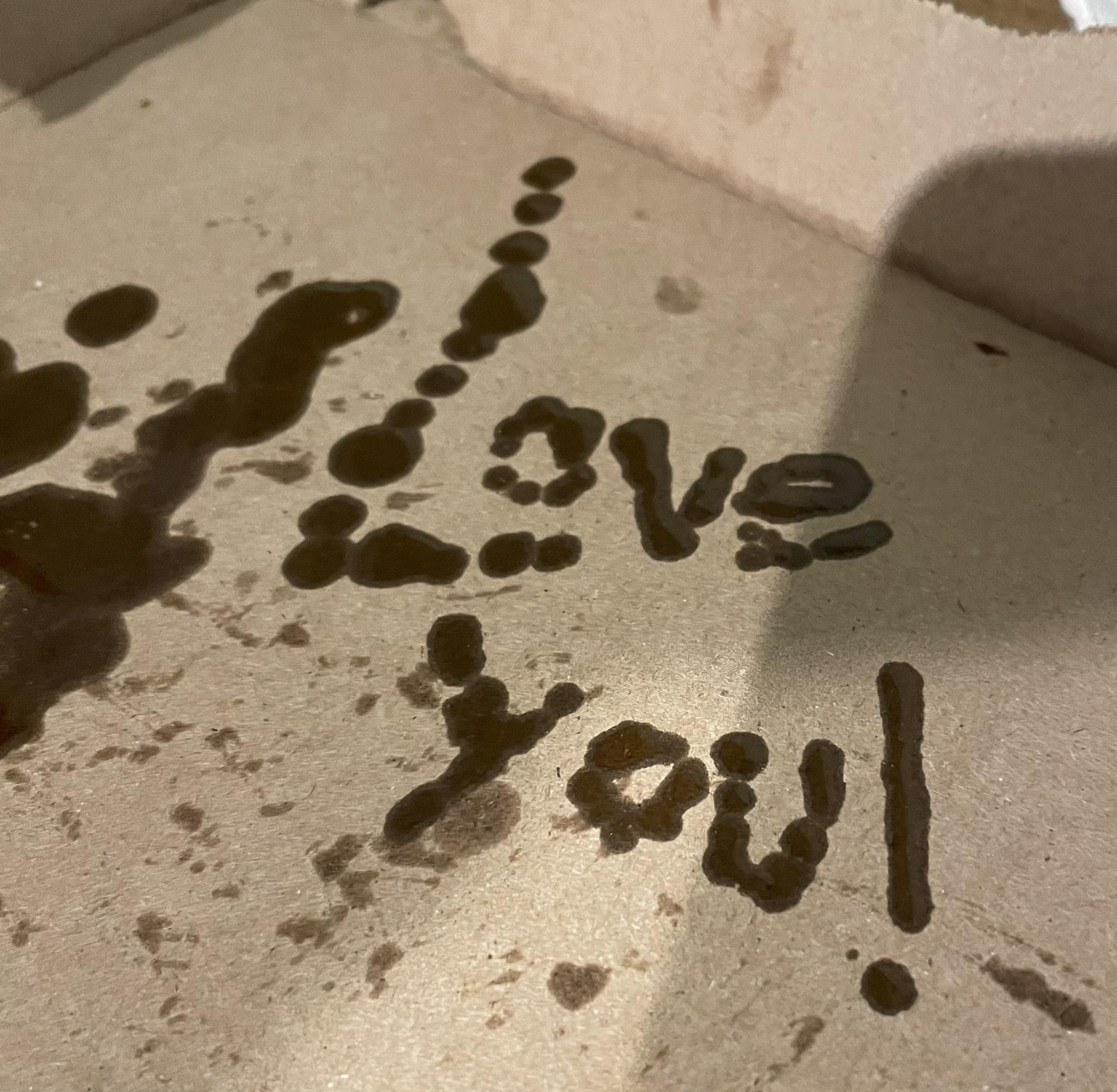 Nothing says romance like “love you,” written in pizza grease!
