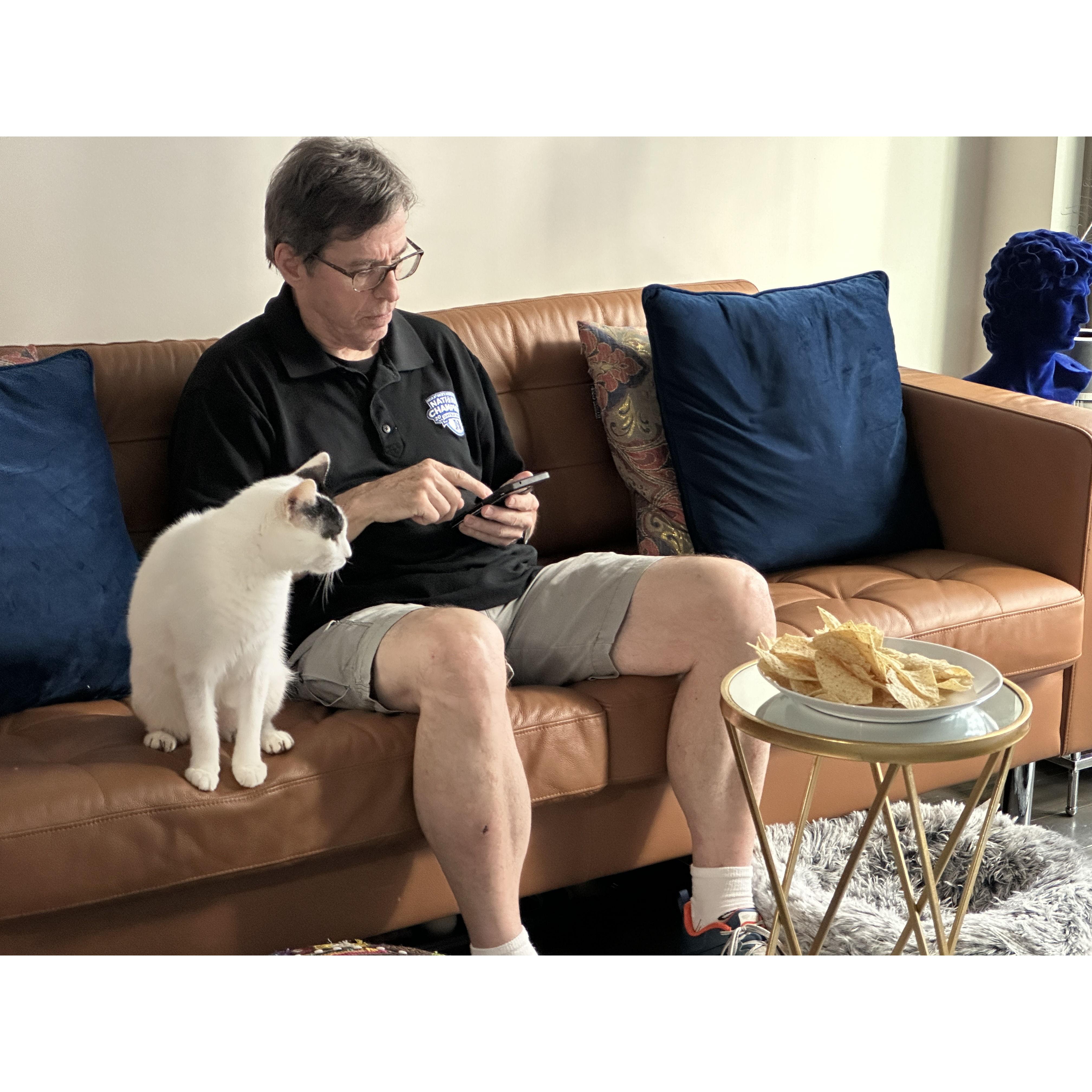 Paul's 3 loves: his phone, a bowl of chips, and Mr. Cat.