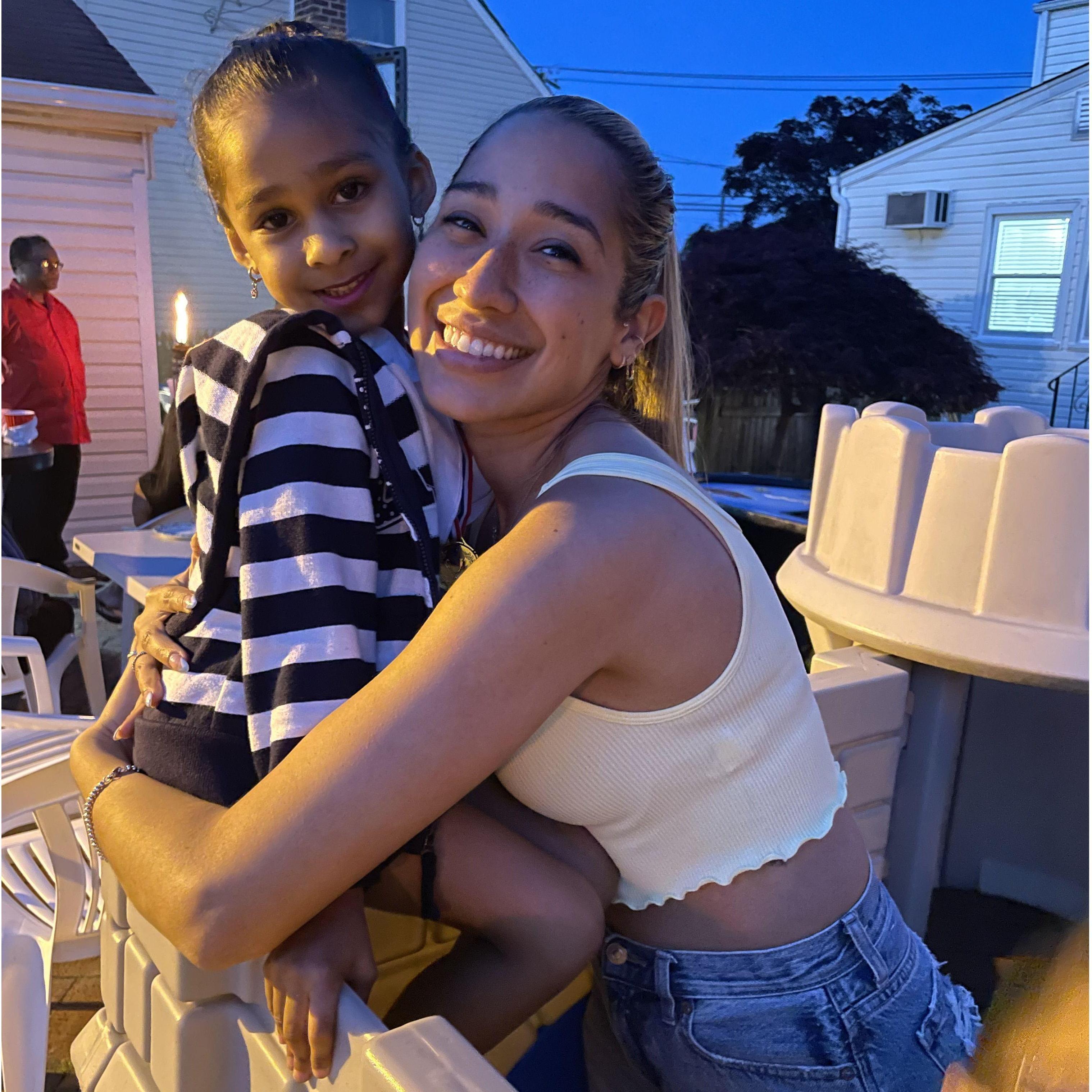Maya the adorable Flower girl and also Deva's daughter share a little hug at a backyard BBQ.