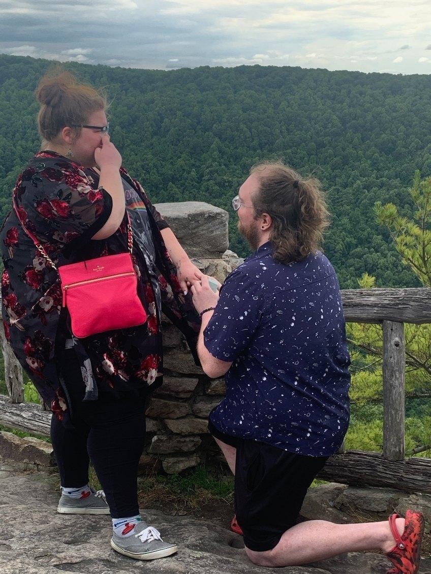 Rob getting down on one knee, asking the question that officially began their lifetime together