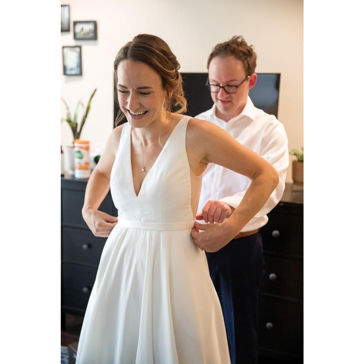 Steve helping Rachel into her wedding dress!