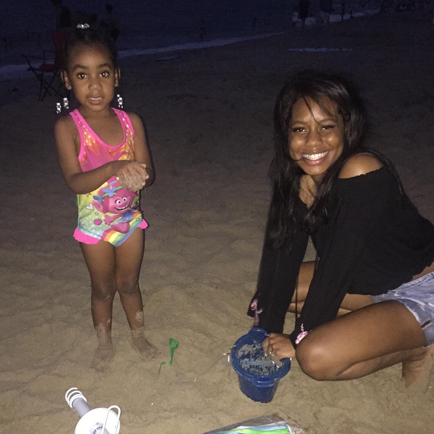 Janiyah and Kayla playing in the sand at the beach.