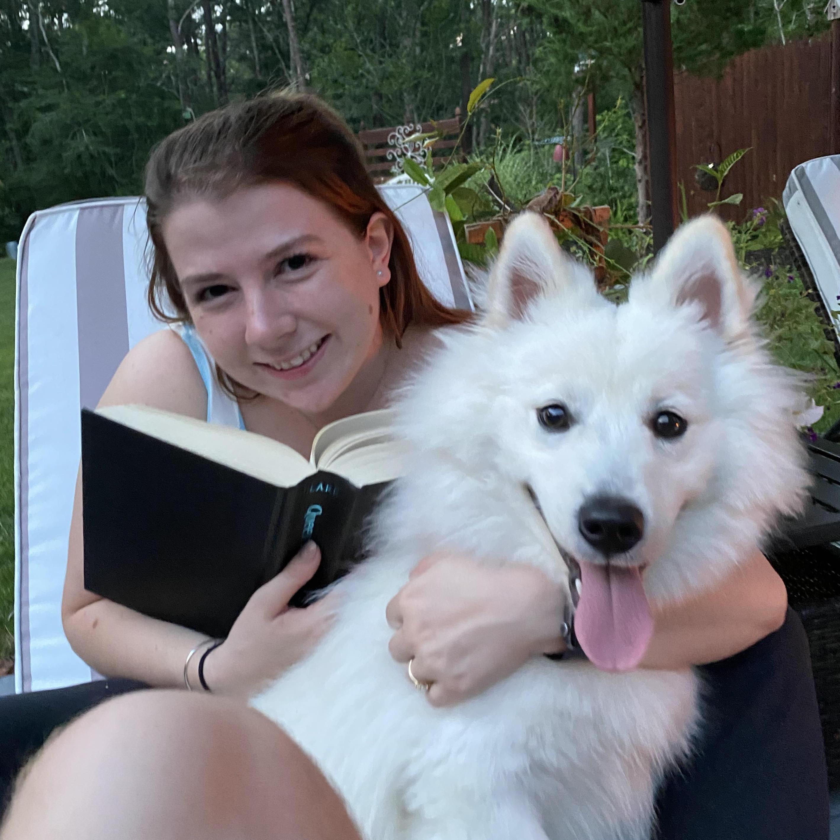 Summer 2021, Mackenzie reading with her mum's dog