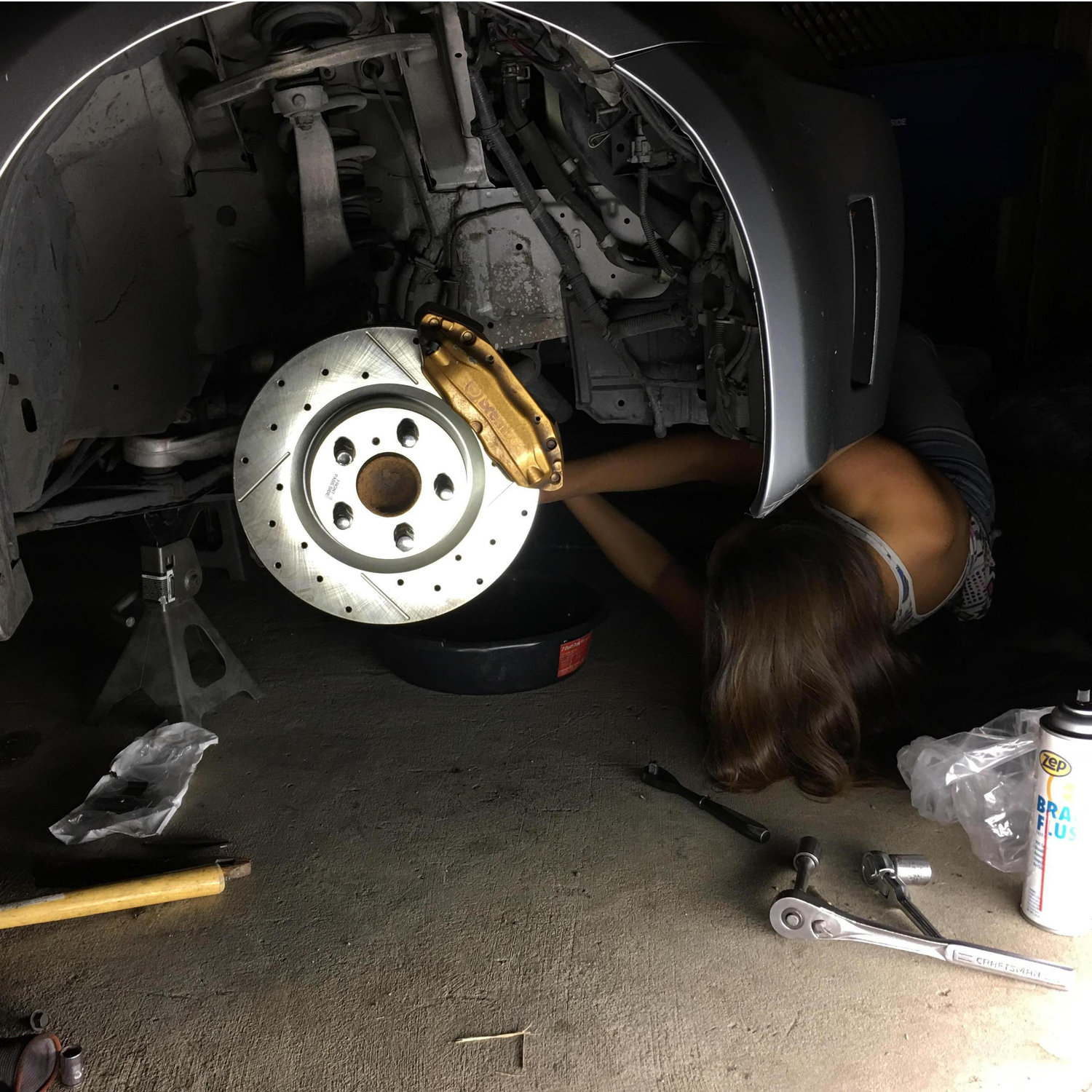 Jasmine working on the Z, learning how to change the brakes.