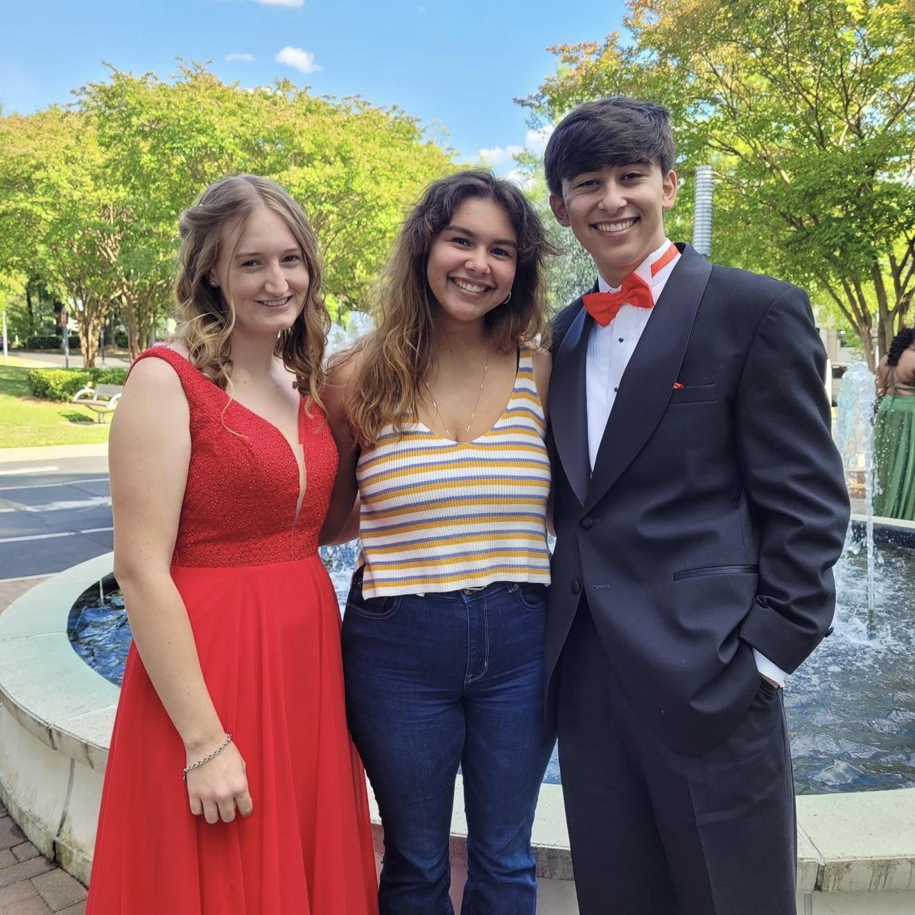 The bride and groom with the grooms sister before prom