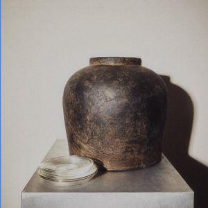 Ceramic vase with a distressed texture.