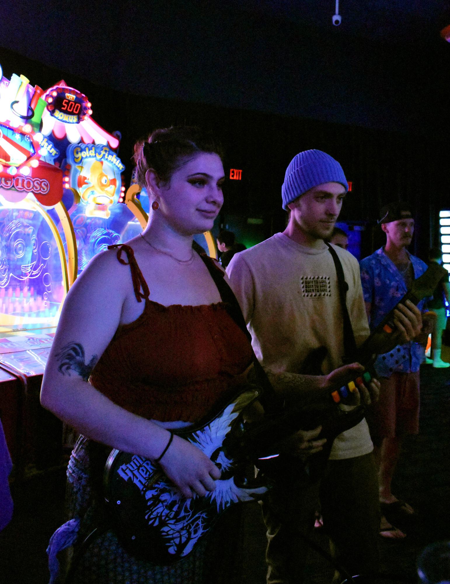 Nathalia (bridesmaid) and Chaison (groomsman) playing guitar hero at the engagement party.