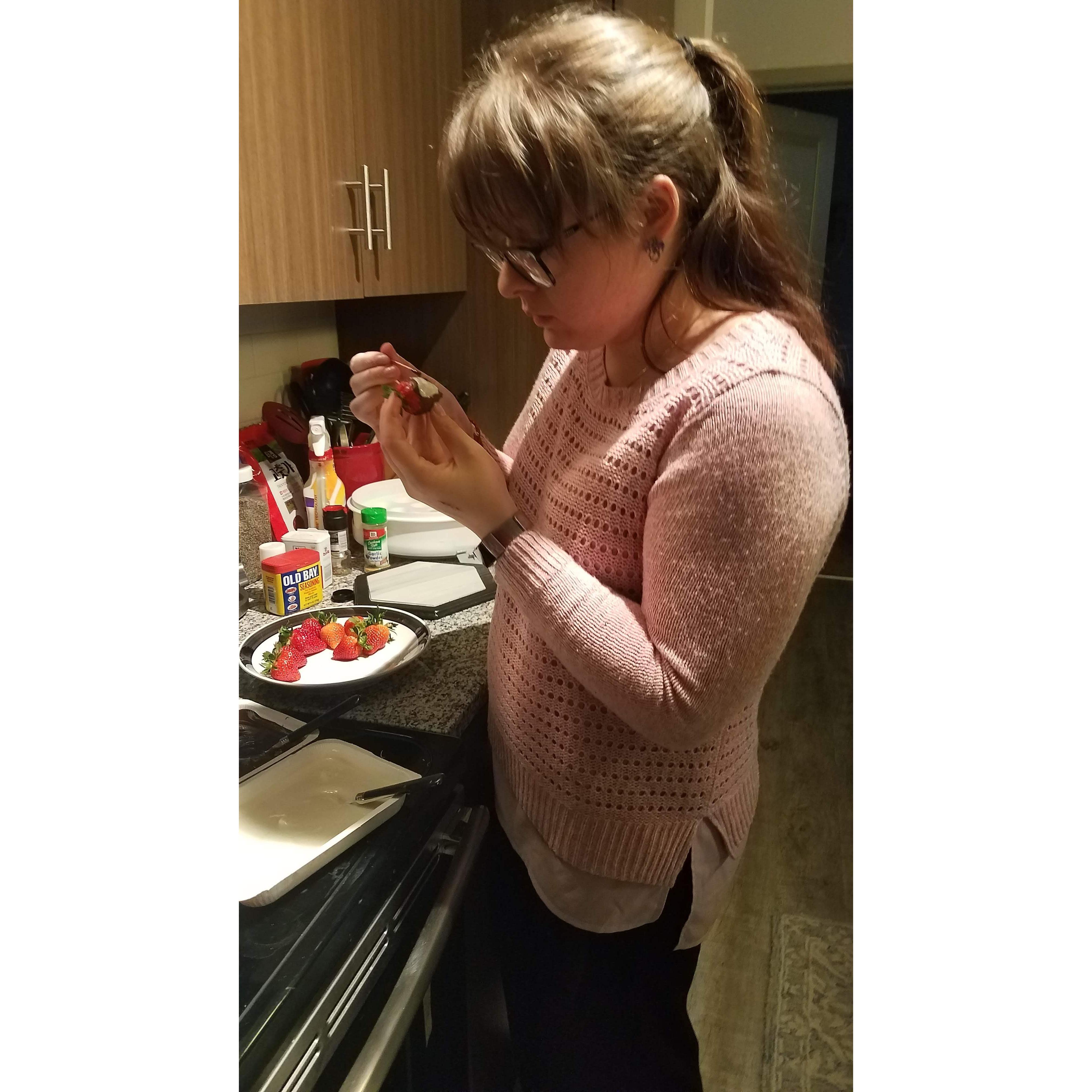 Megan concentrating on decorating a chocolate covered strawberry for Phil
