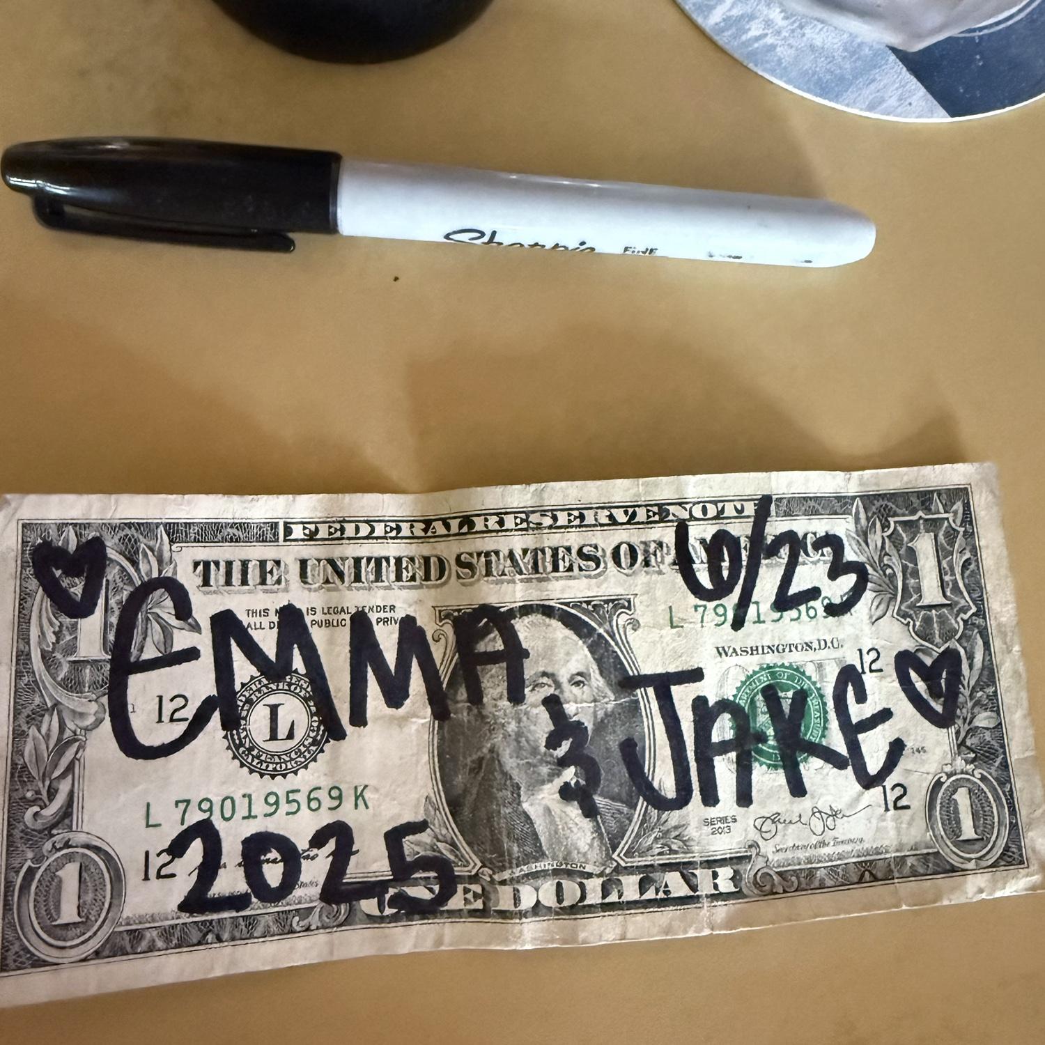 The day we got engaged! A bar we went to in Sandpoint ID that day had dollar bills people wrote on all over the walls. This was the one we made!
