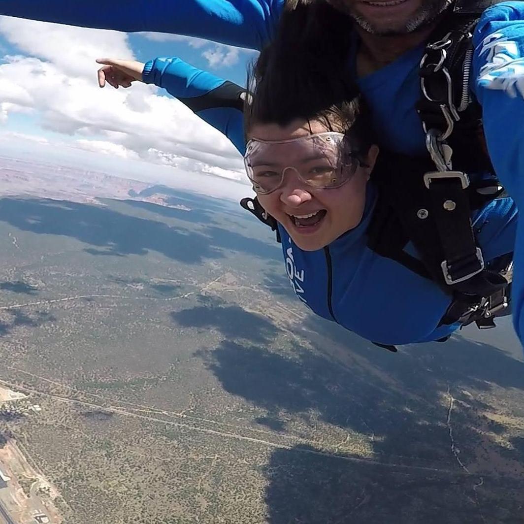 Flying tandem with her skydiving instructor about 13,000 ft in the air.