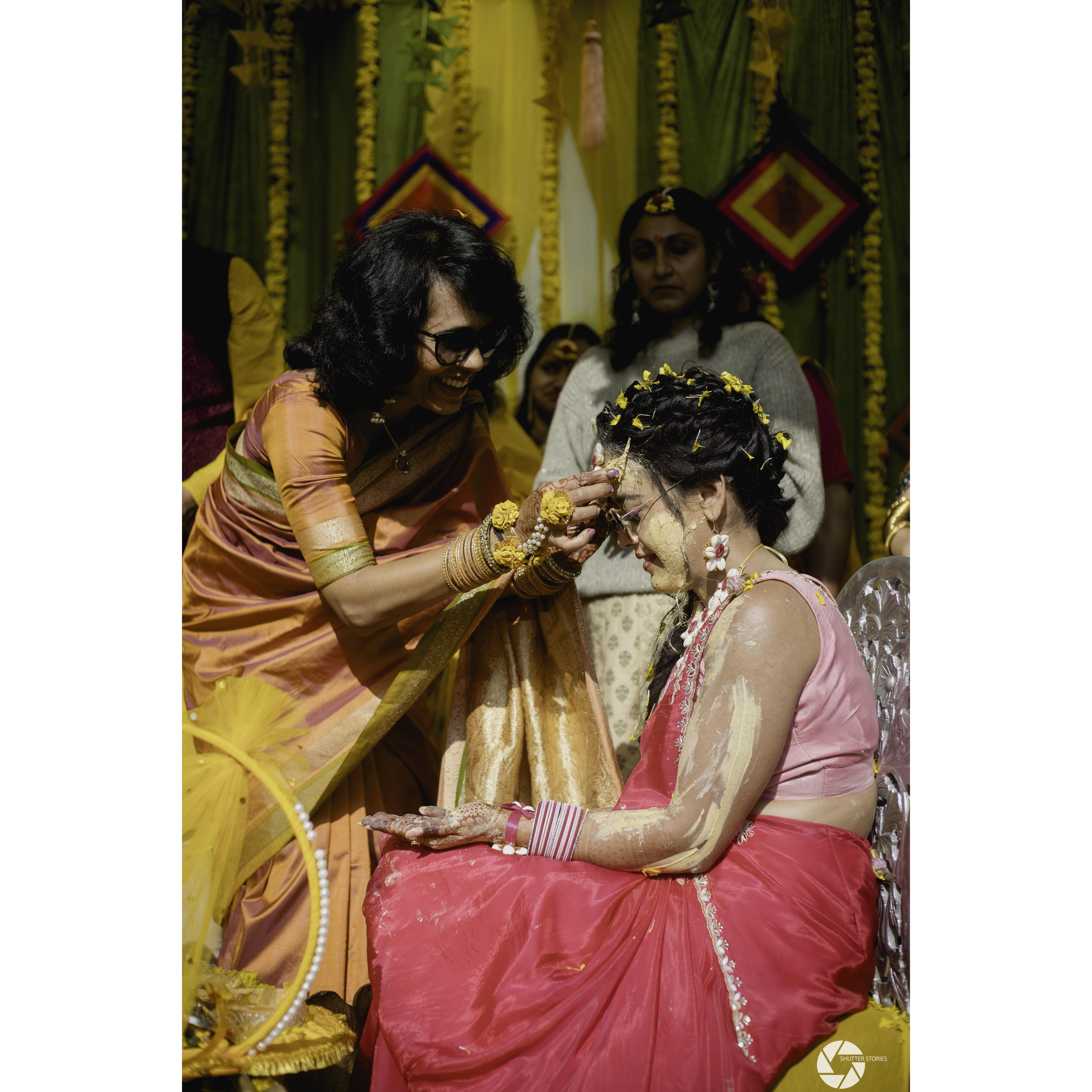 The "Haldi" ceremony. The family applies a turmeric based paste on the bride and groom to "beautify" them for the big day