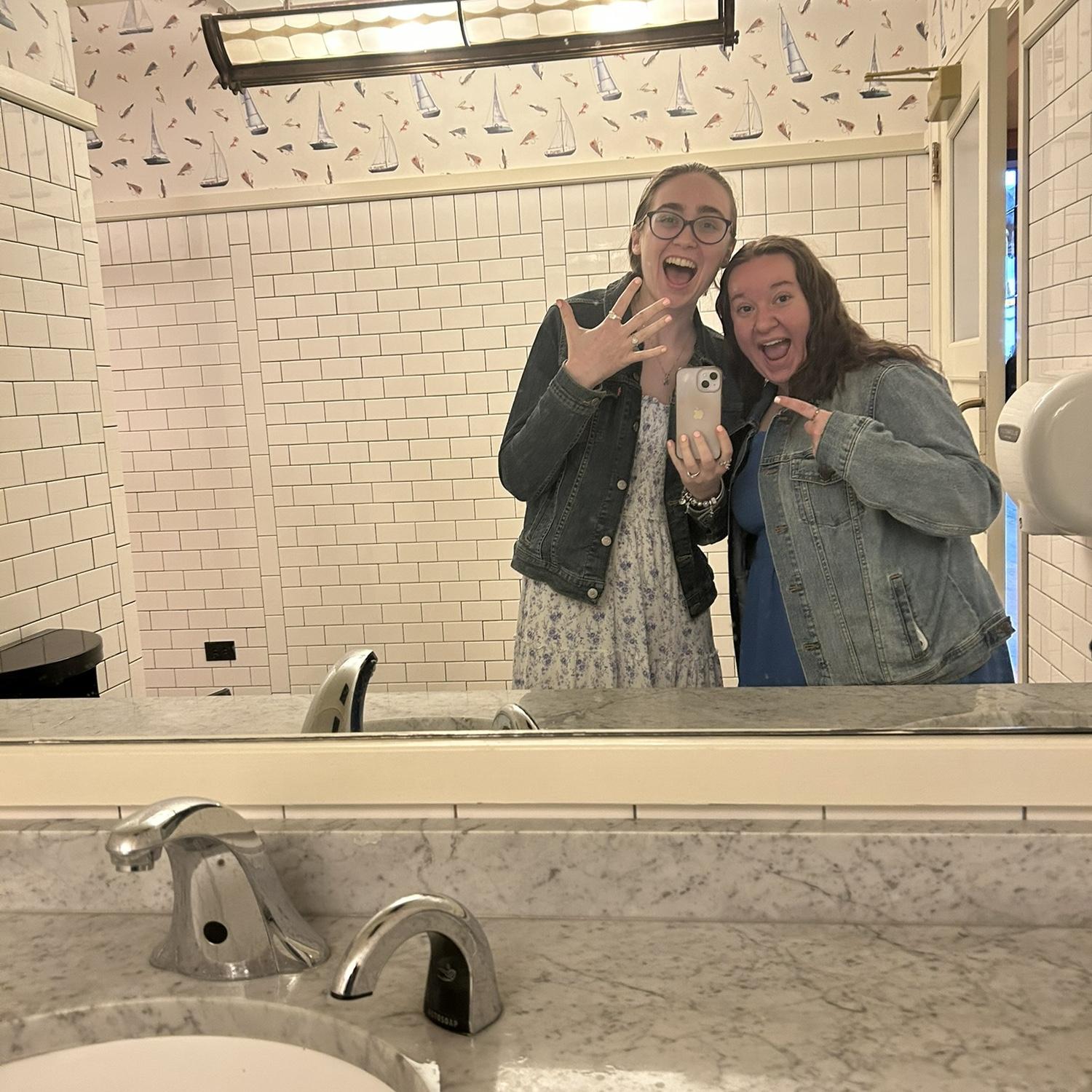 Kristen and Ally (Maid of Honor) right after the proposal, celebrating the proposal in the bathroom mirror at the rooftop bar!