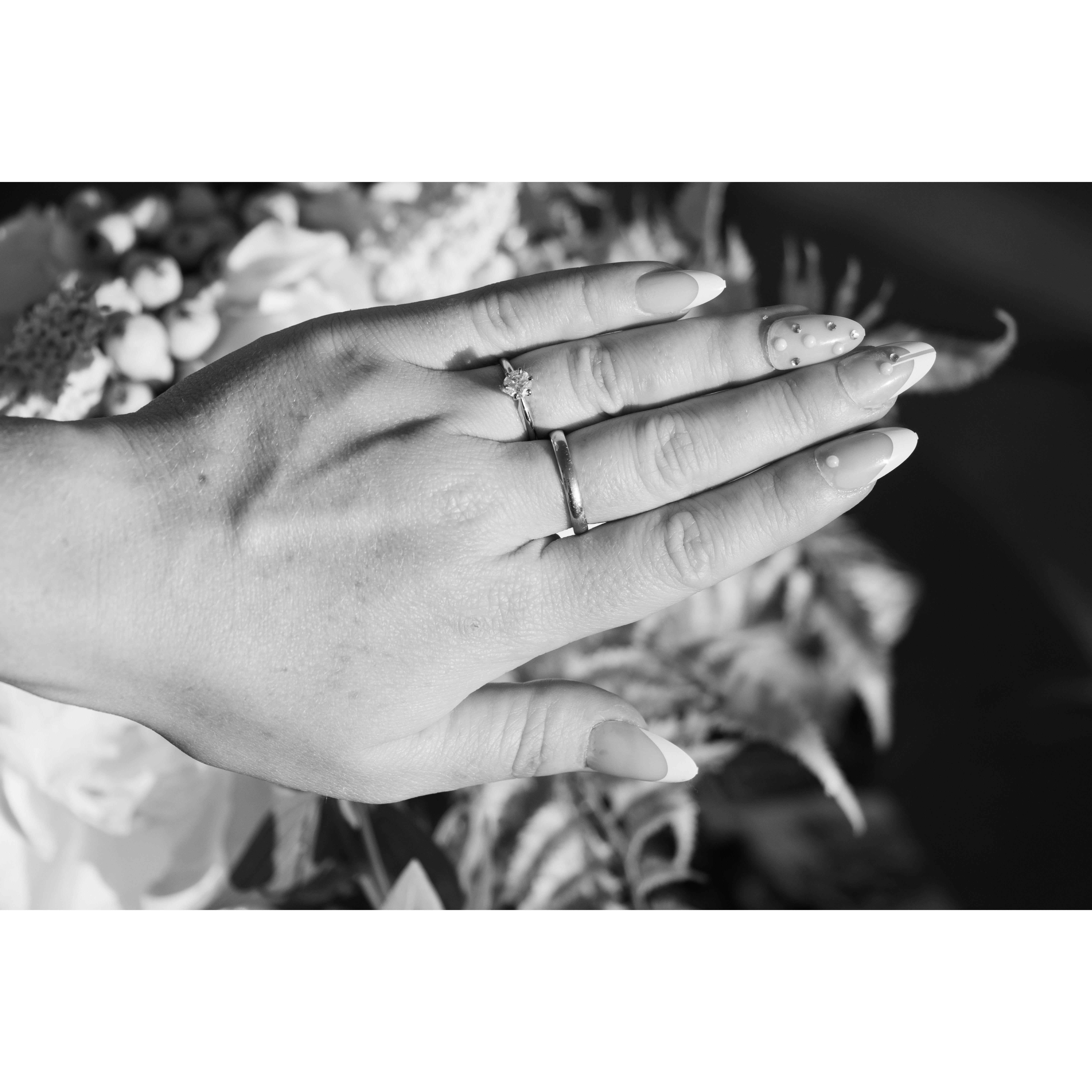 Max made Joy's wedding band from scratch (third finger), and she wears her grandmother Elinor's engagement ring on her fourth finger.