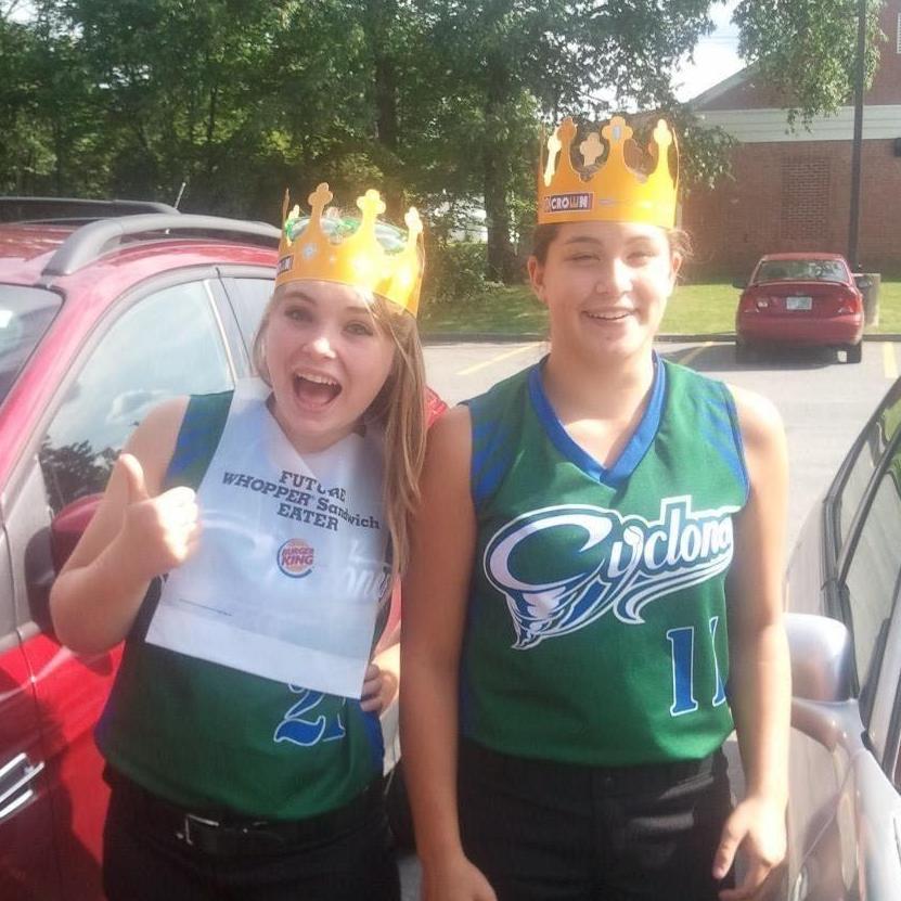 Steph & Kayla wearing the Burger King crowns while traveling for a softball tournament
