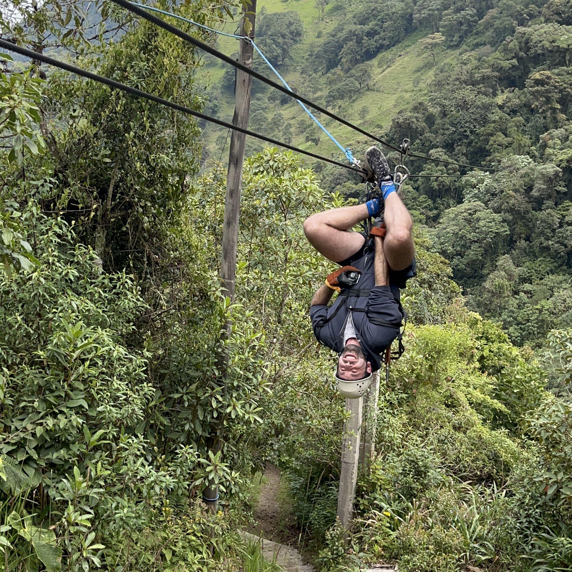 Amazon - Michael hanging upside down on the zip-line cables, fully embracing the adventure. He might not be a monkey, but he definitely mastered the moves!