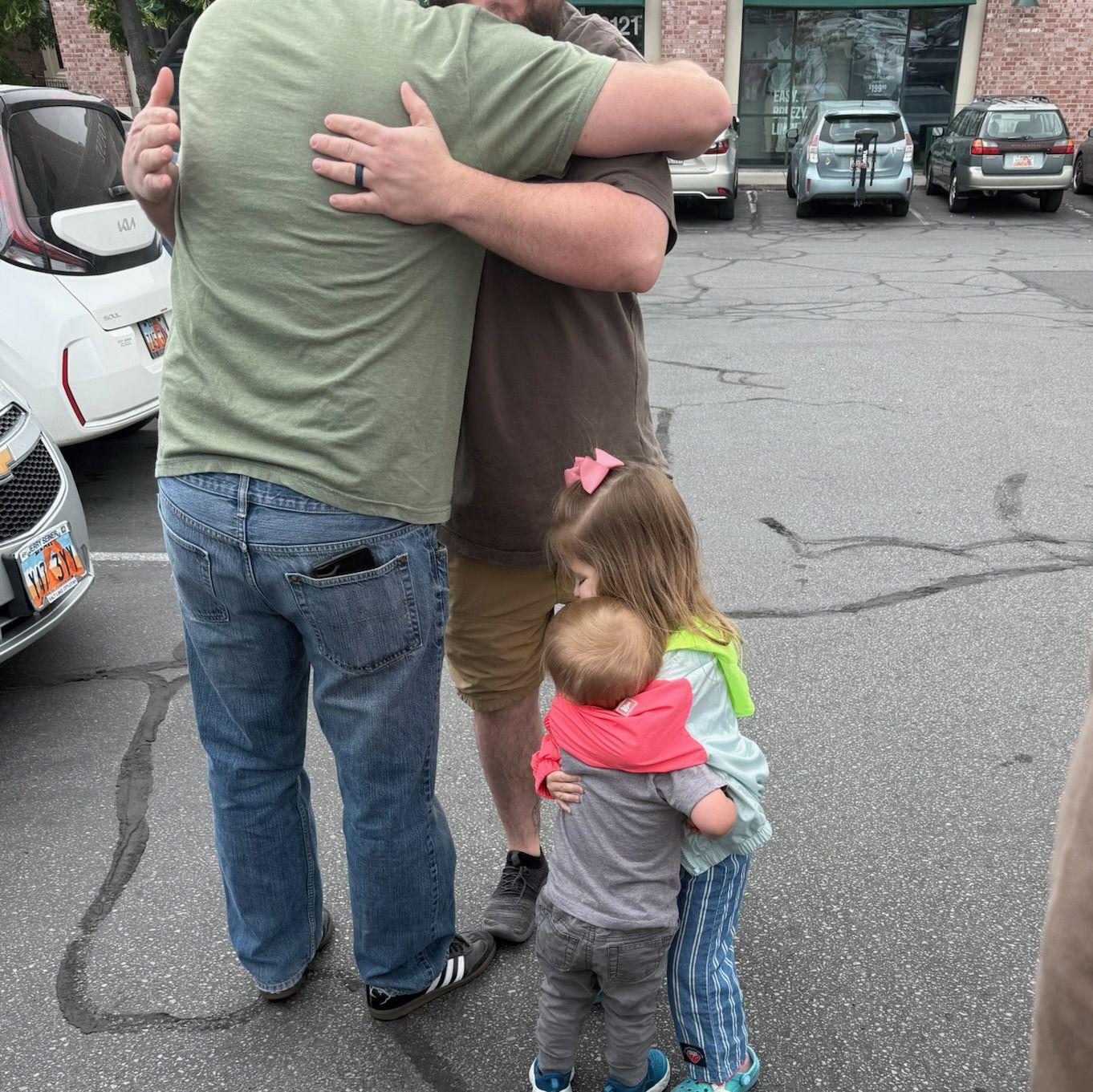 Two tiny besties and their dad's hugging goodbye