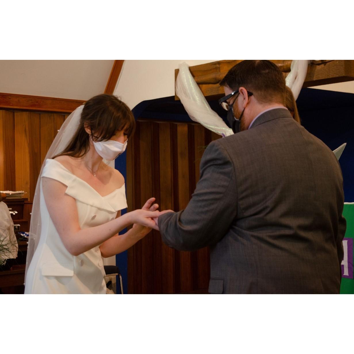 Maxine putting Jason's ring on his finger.