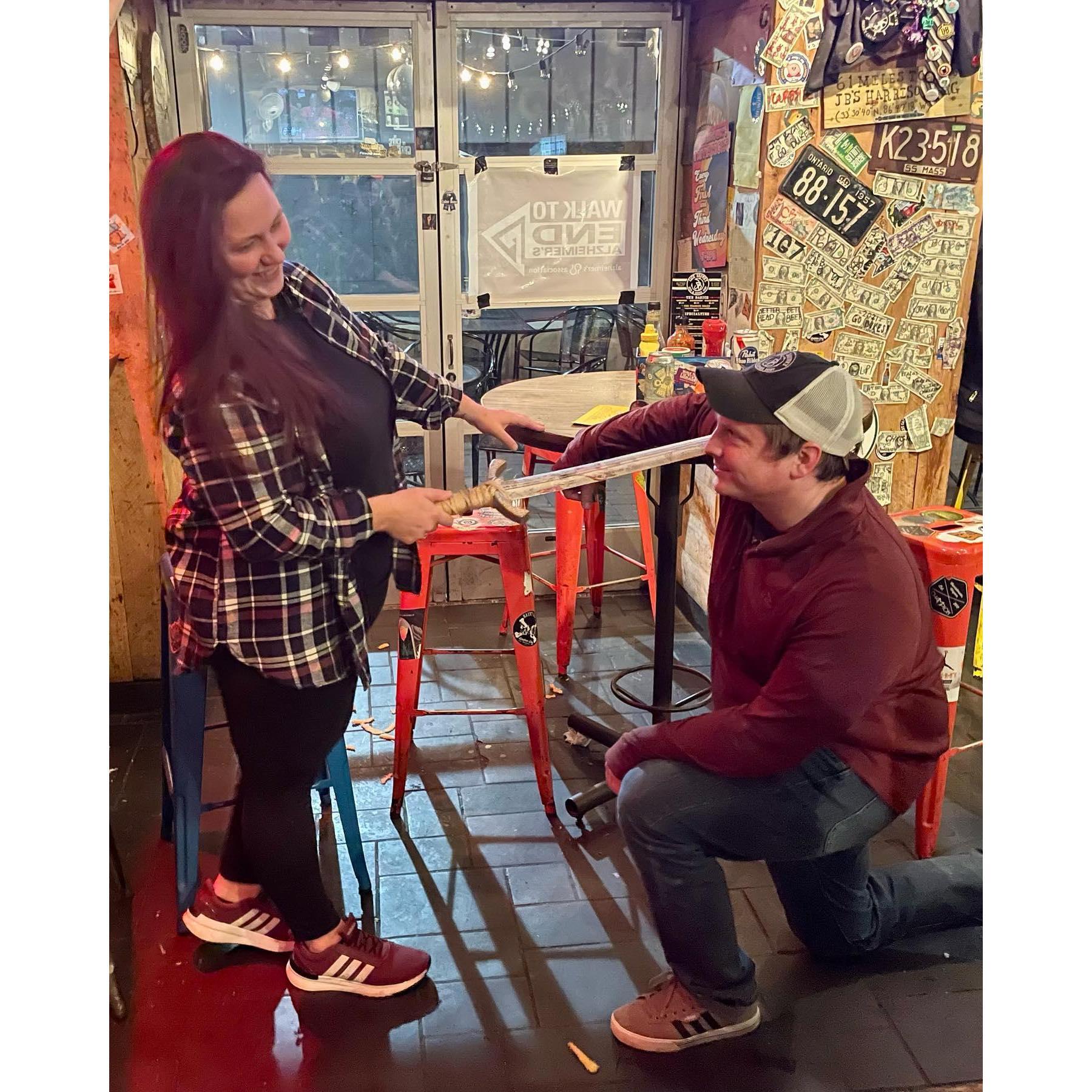 The first time Greg got on his knee... for JB's Knighthood!