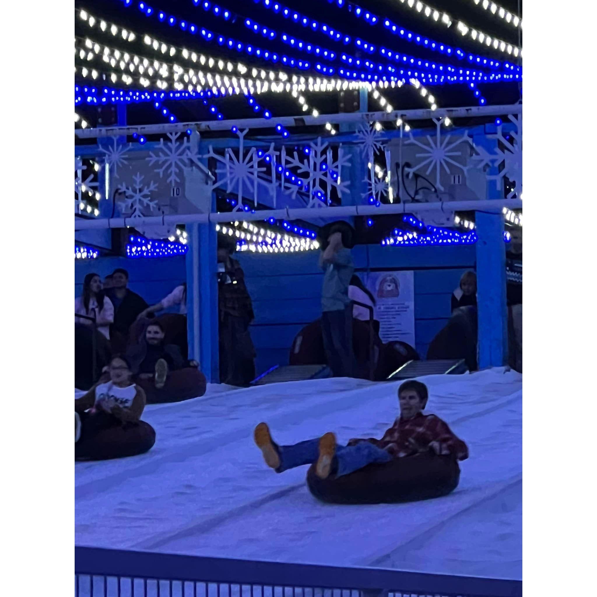 Brandon sliding down the snow hill in a toob at Santa's Wonderland