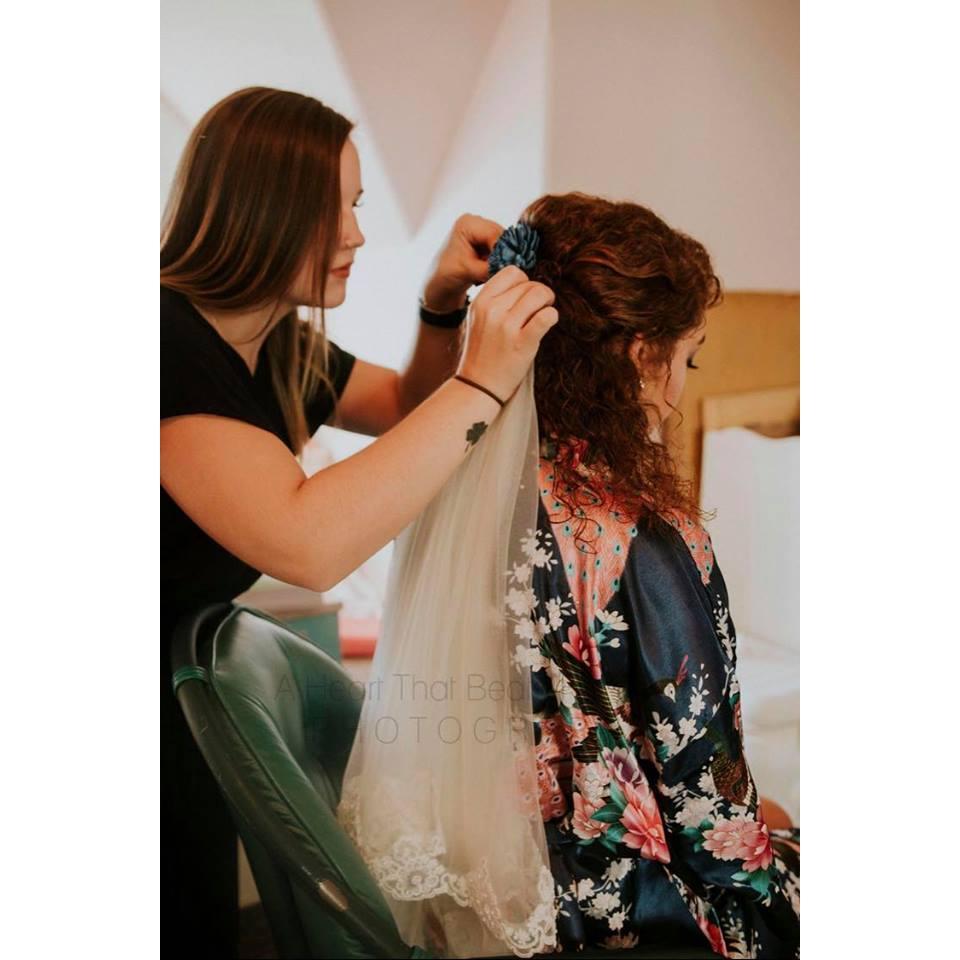 Emily Elliott helping the bride with her veil 
Photo credit to: A Heart That Beats For One Photography