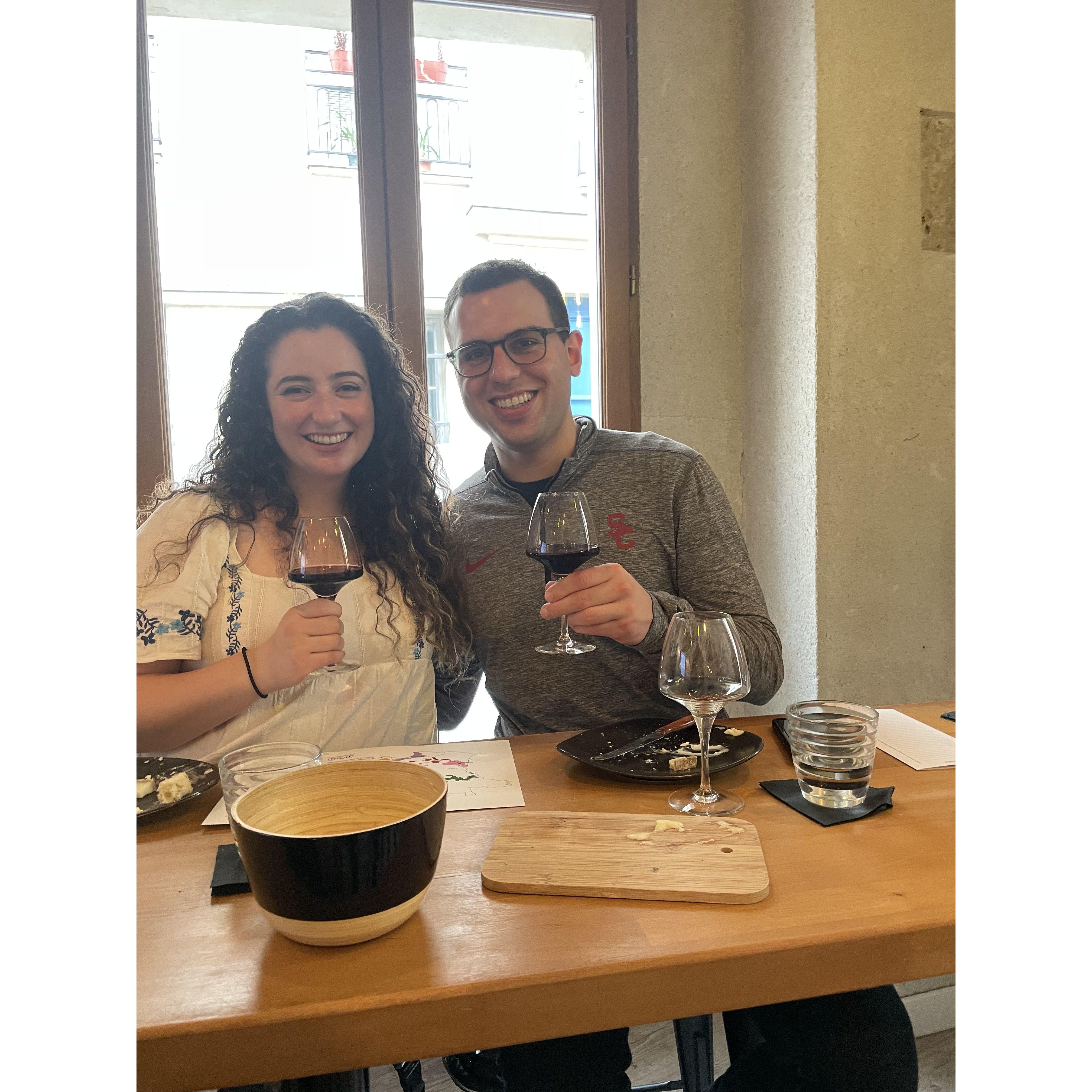 October 2023: They traveled to France and Italy! This was taken during a wine & cheese pairing class in Paris.