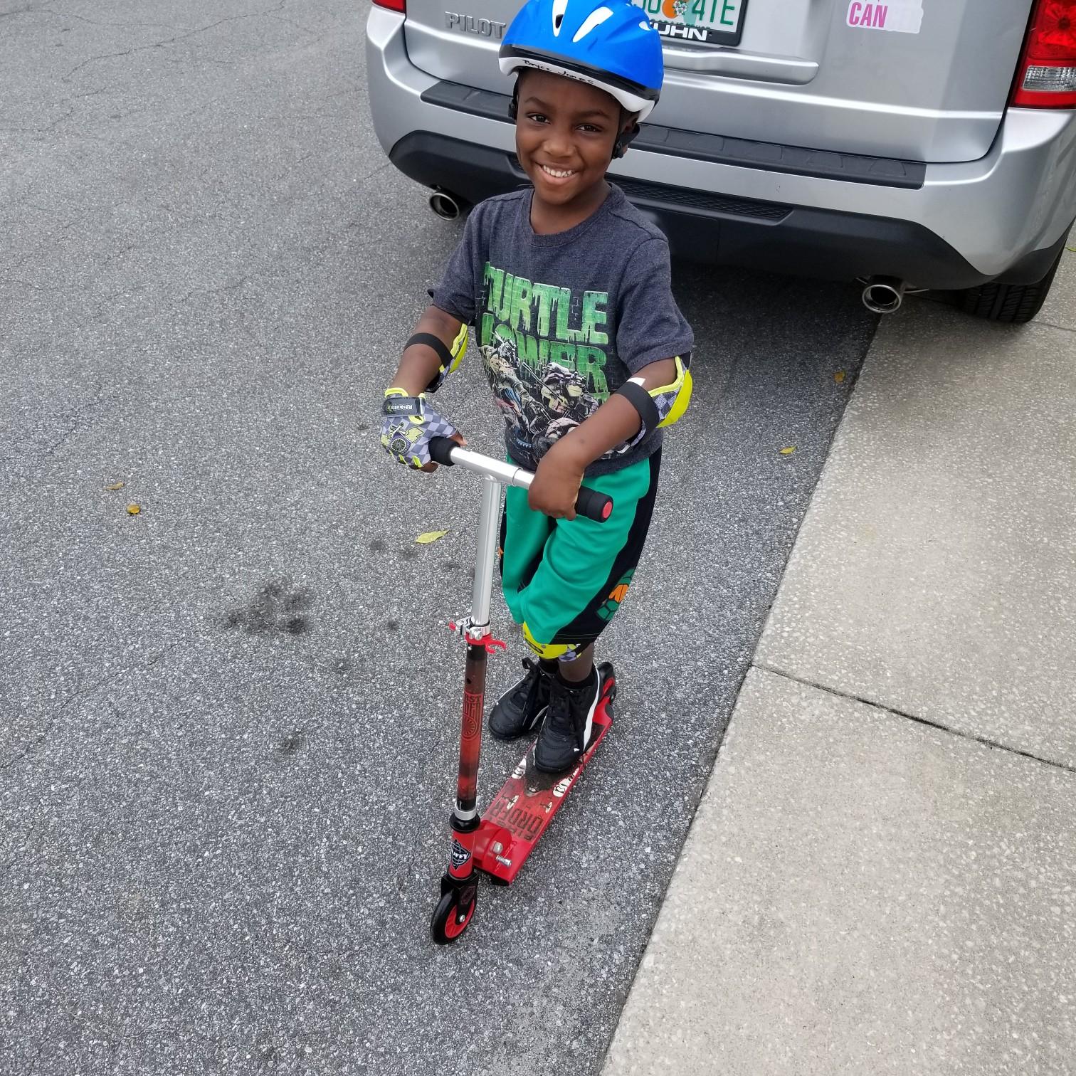 Safety First: Bryce is happy his Nana bought him a scooter! Pads on for safety and off he goes!