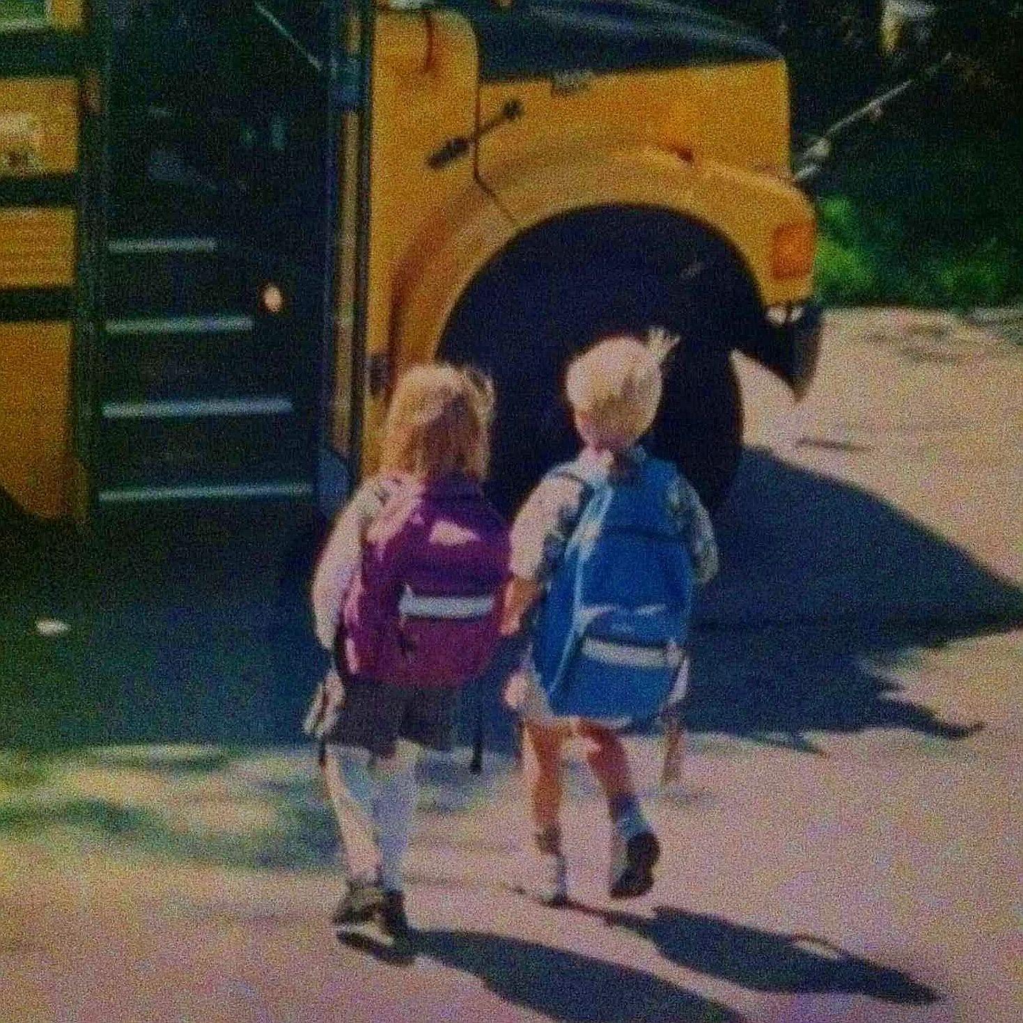 Emily and Karl's first day of school, walking onto the bus holding hands
