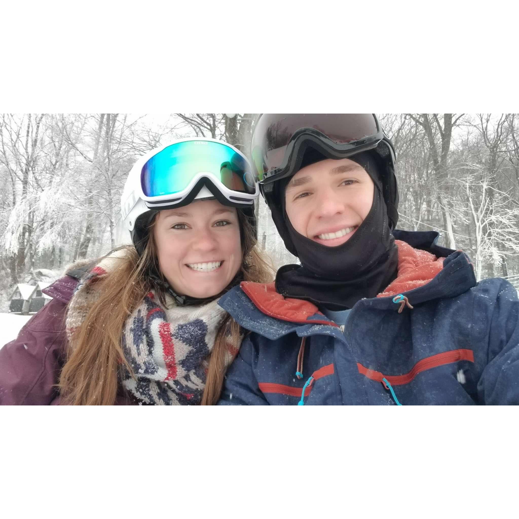 Tanner attempting to teach Meg to snowboard