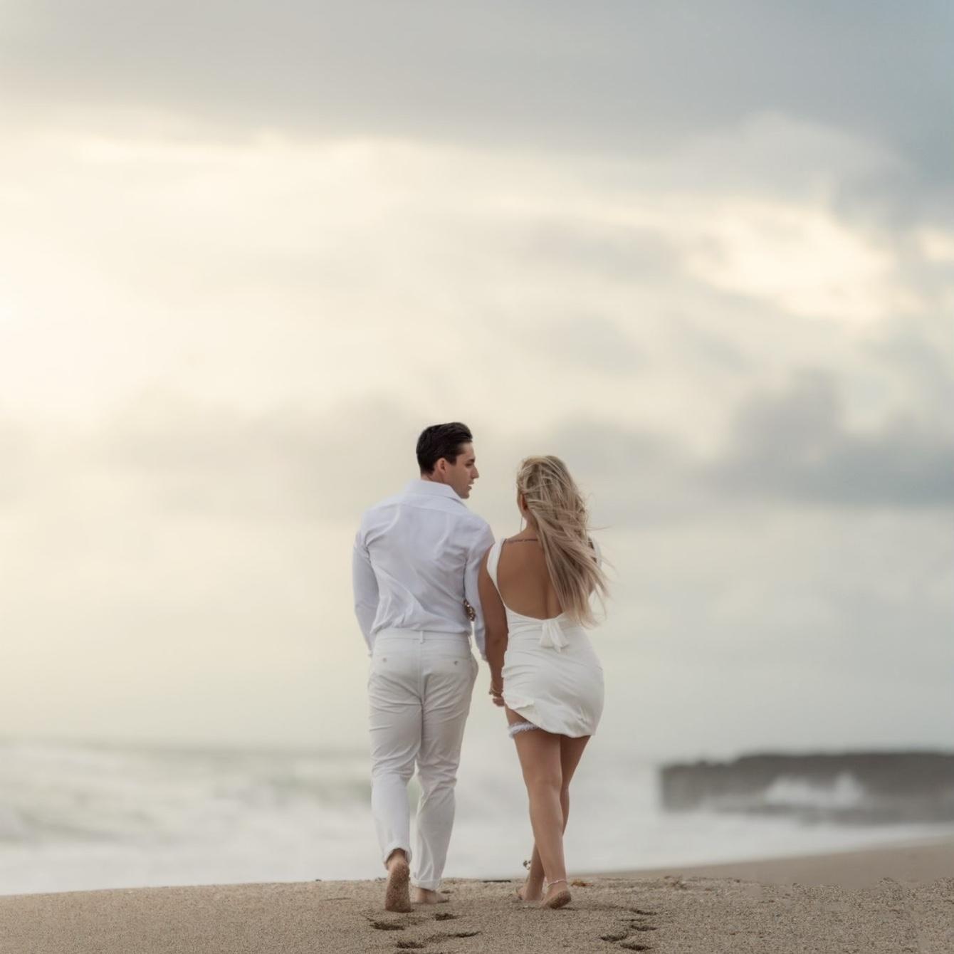Enjoying a romantic stroll along the beach at sunrise.