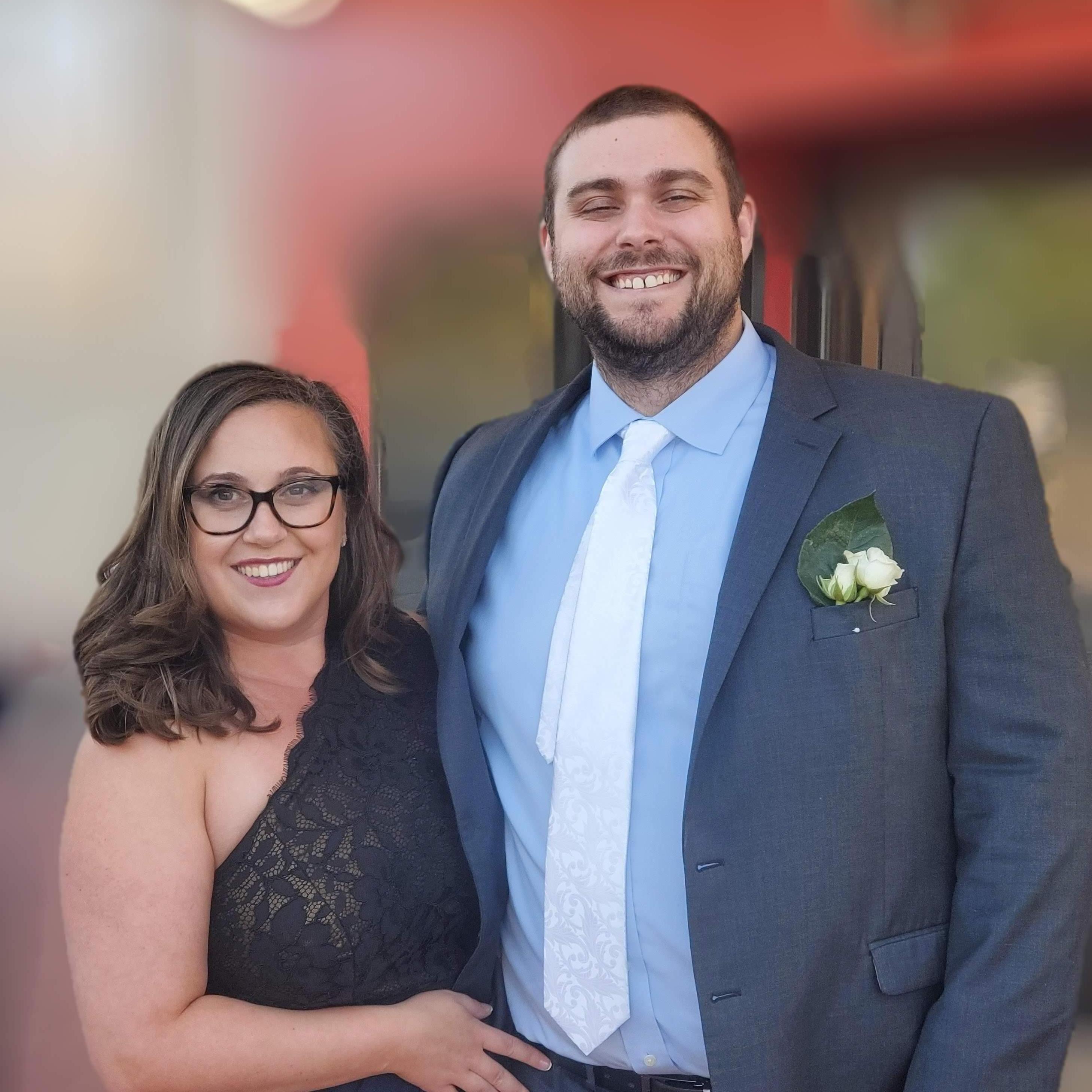 Alt Text: portrait mode photo of Maeghan and Keiran all dressed up at his sister Sydney's wedding in MI