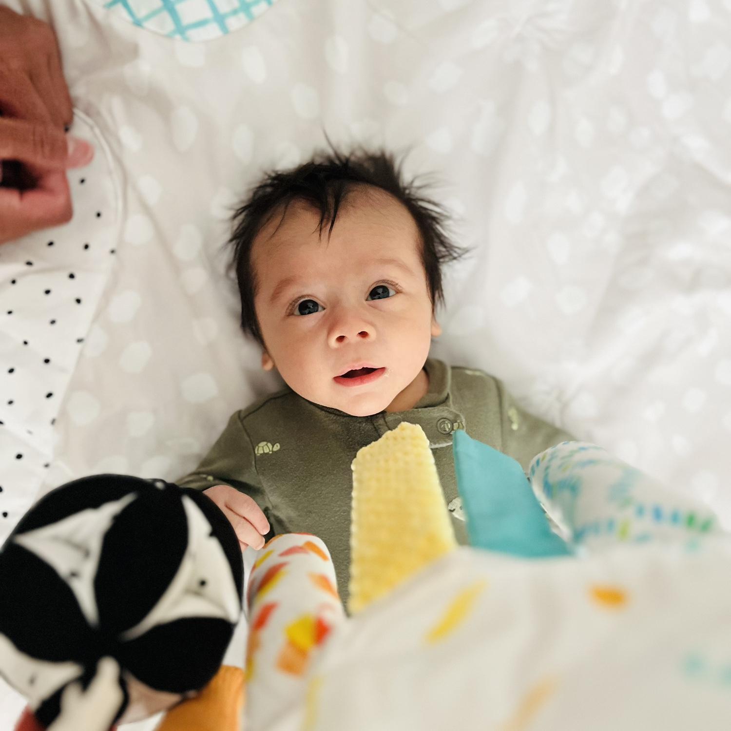 Baby Jeffrey in his play gym, more laying than playing at this point.