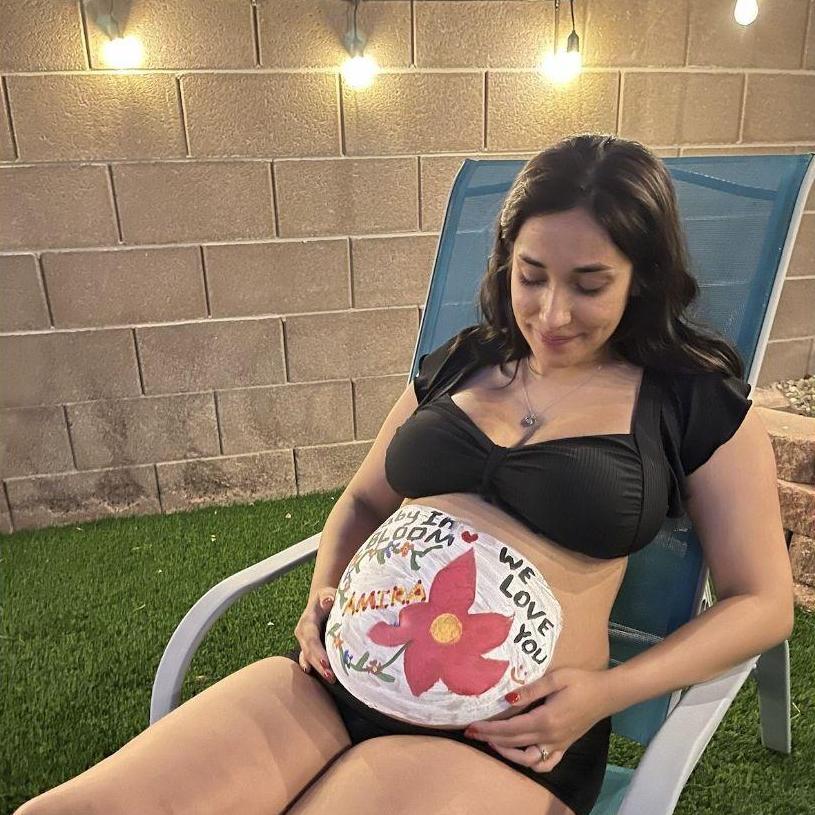 Laith painting Ana's baby belly