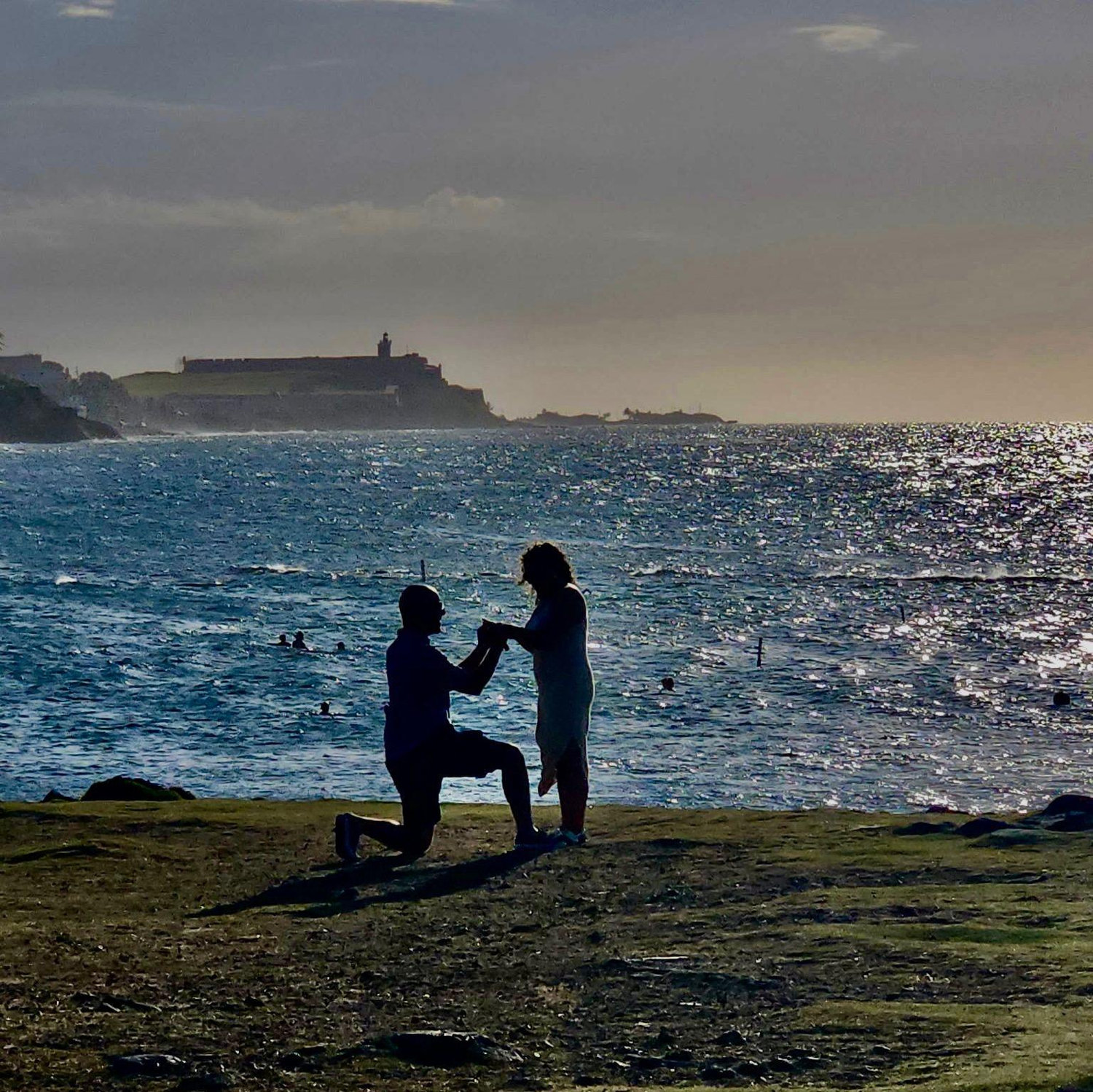 7/7/25 The proposal! This photo was taken by a bystander. Look at how beautiful the sunset, blue waters, and El Morro are in the backdrop! Truly magical.
